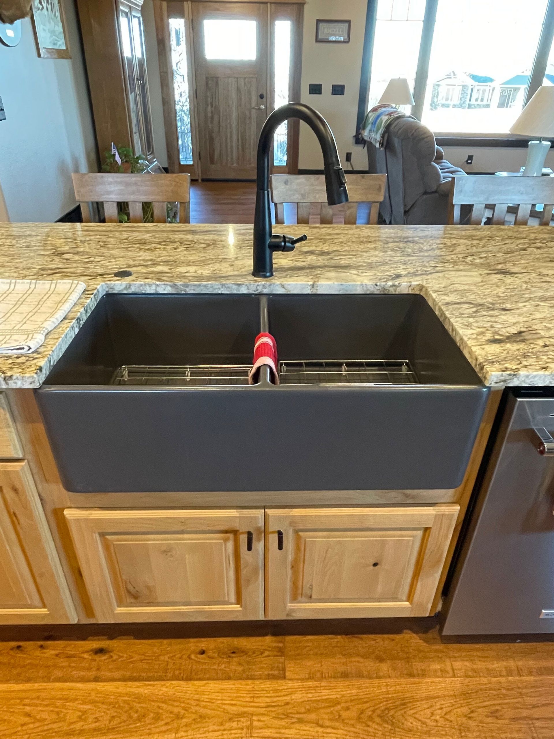 A kitchen sink is sitting on top of a granite counter top.