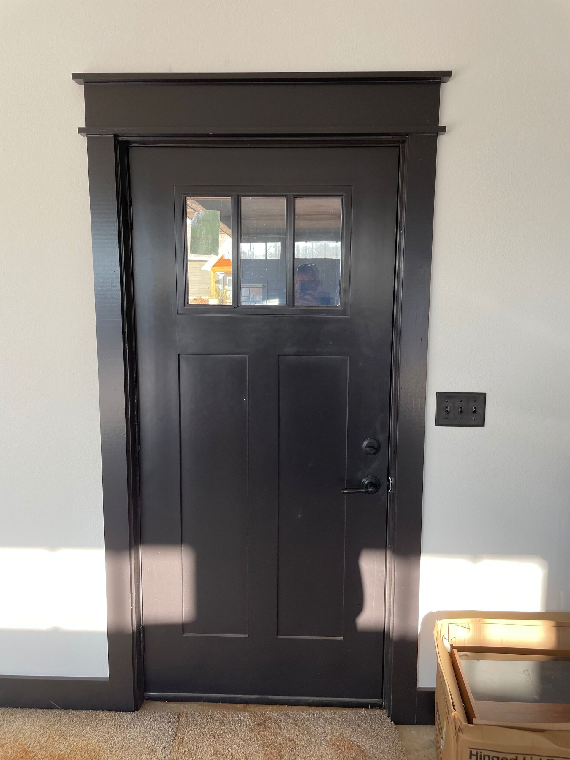 A black door with a window in a room