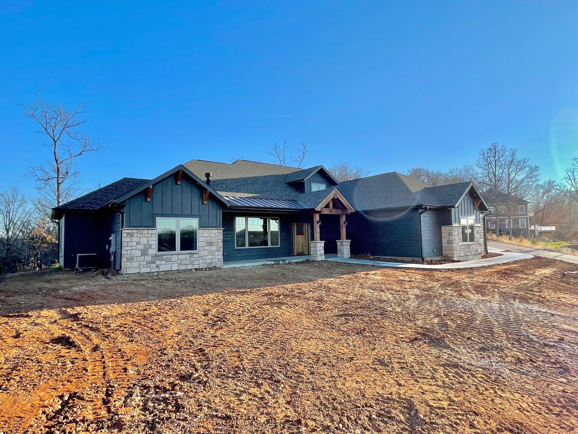 A large house is sitting on top of a dirt field.
