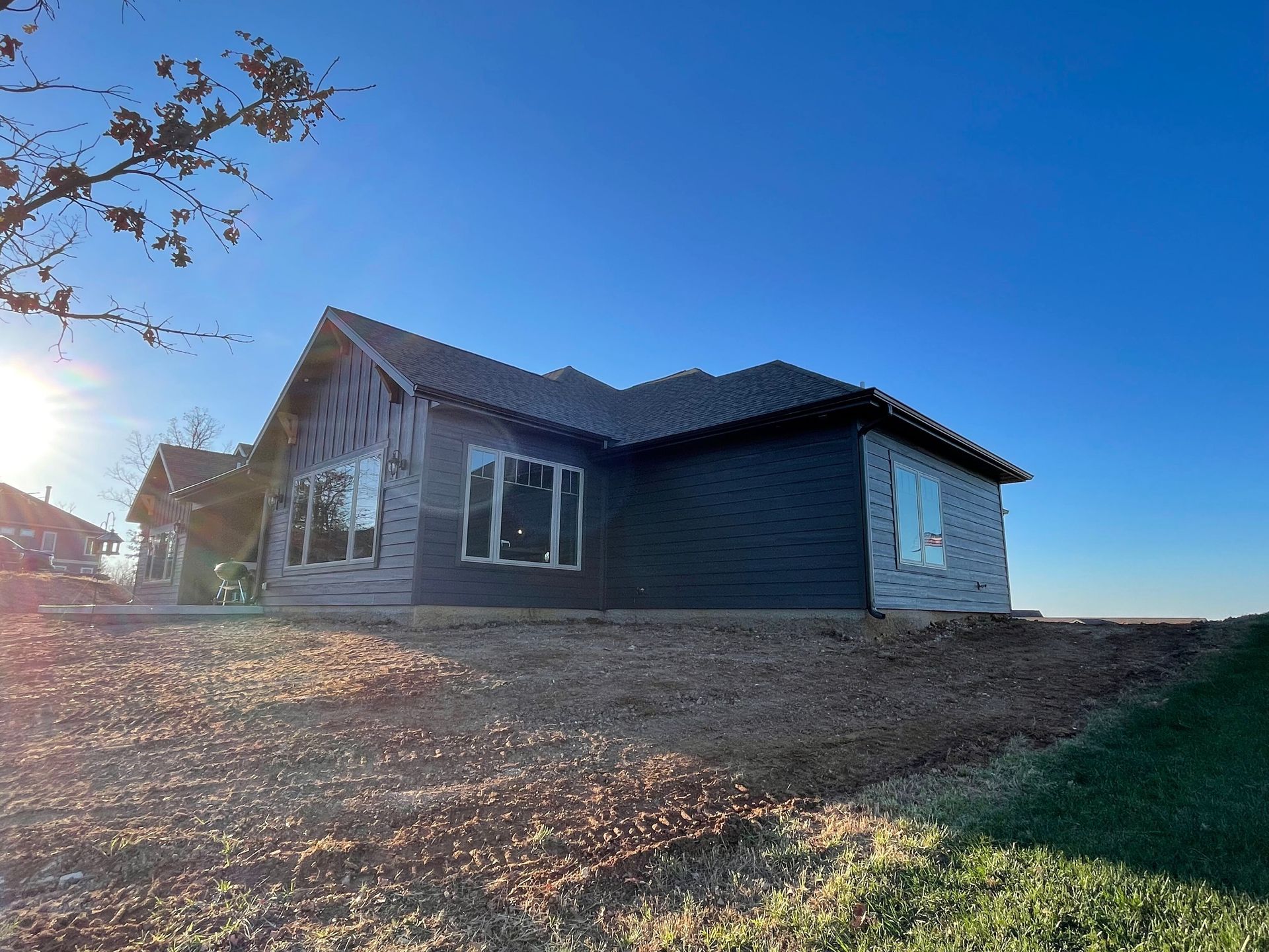A large house is sitting on top of a dirt hill.