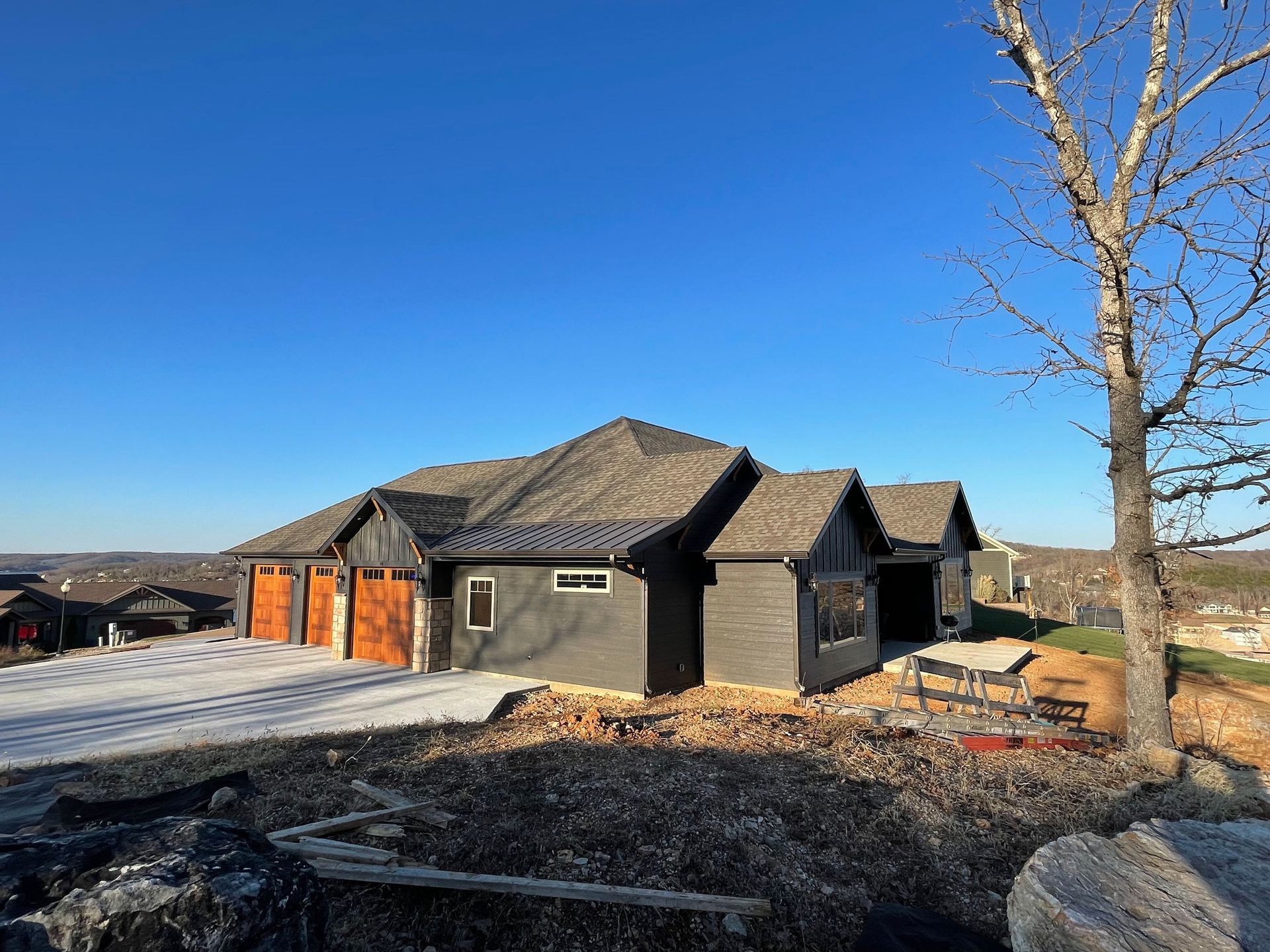 A house is being built on a hill with a tree in front of it.