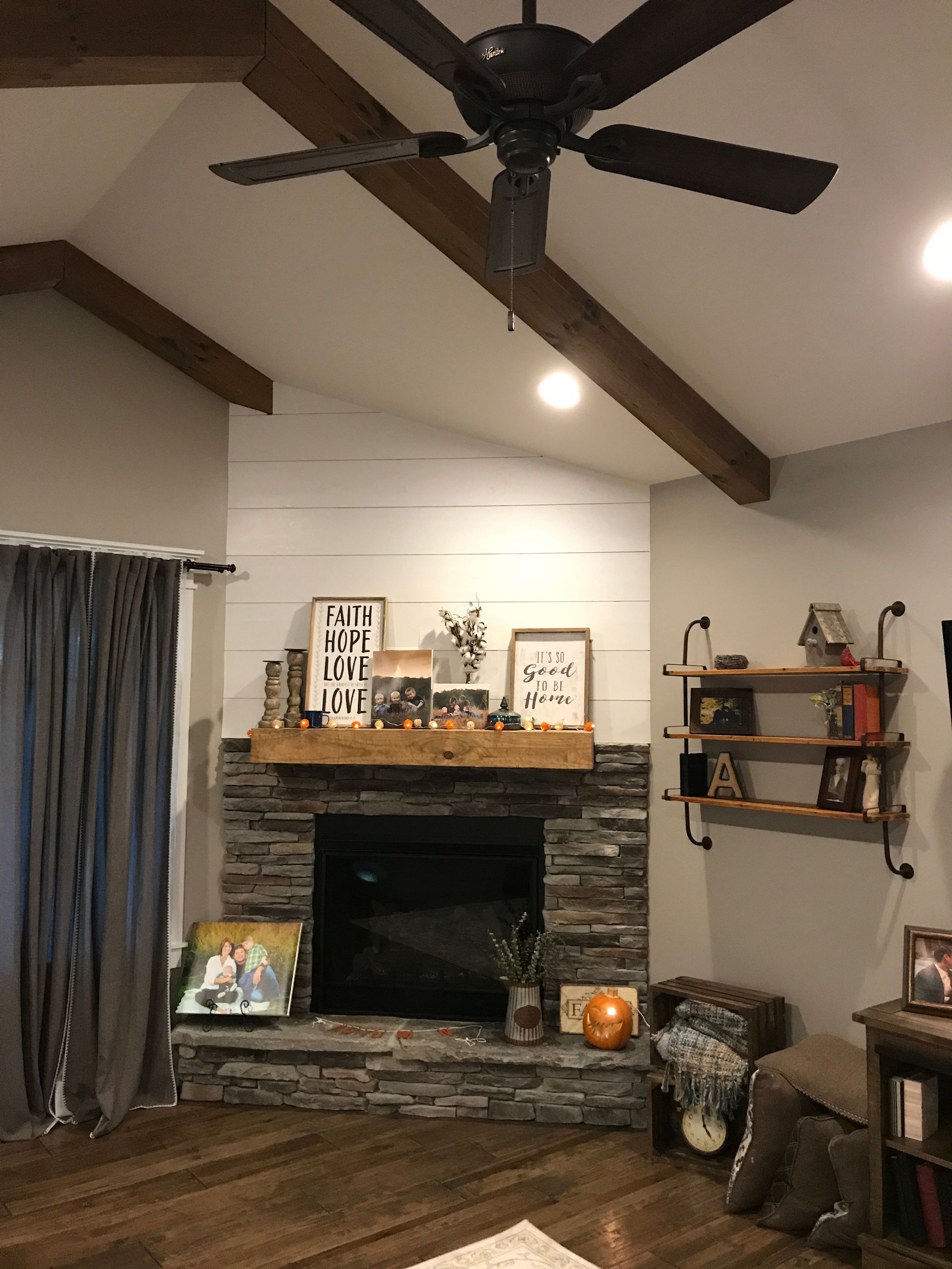 A living room with a fireplace and a ceiling fan