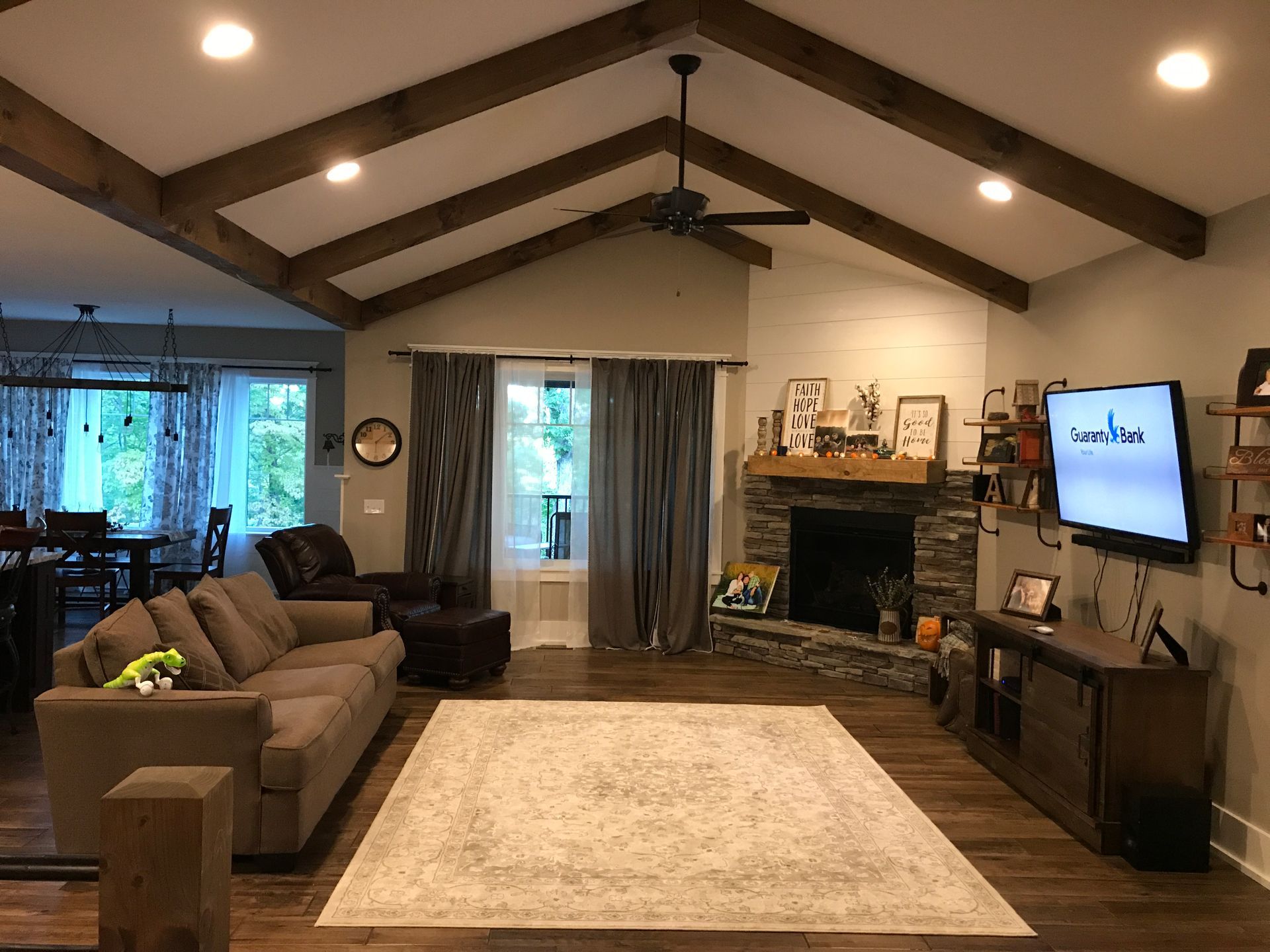 A living room with a couch , chair , fireplace and television.
