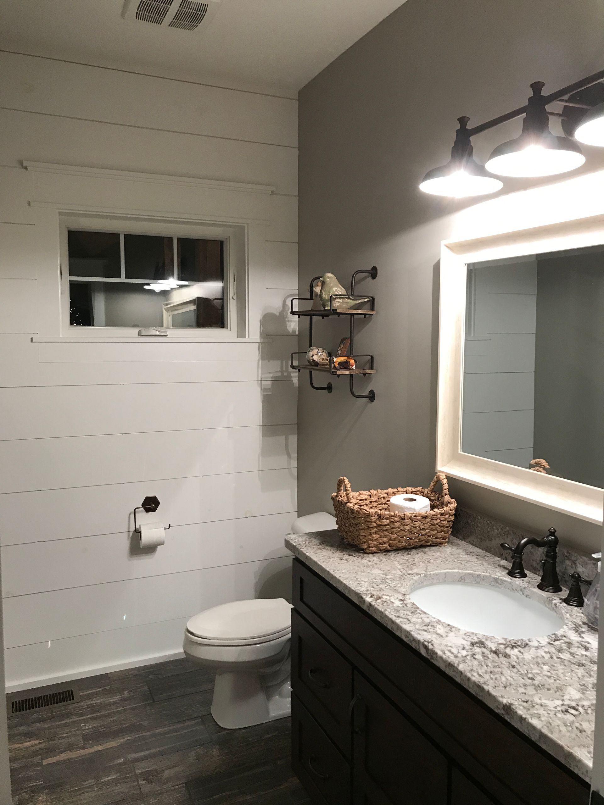 A bathroom with a toilet , sink and mirror