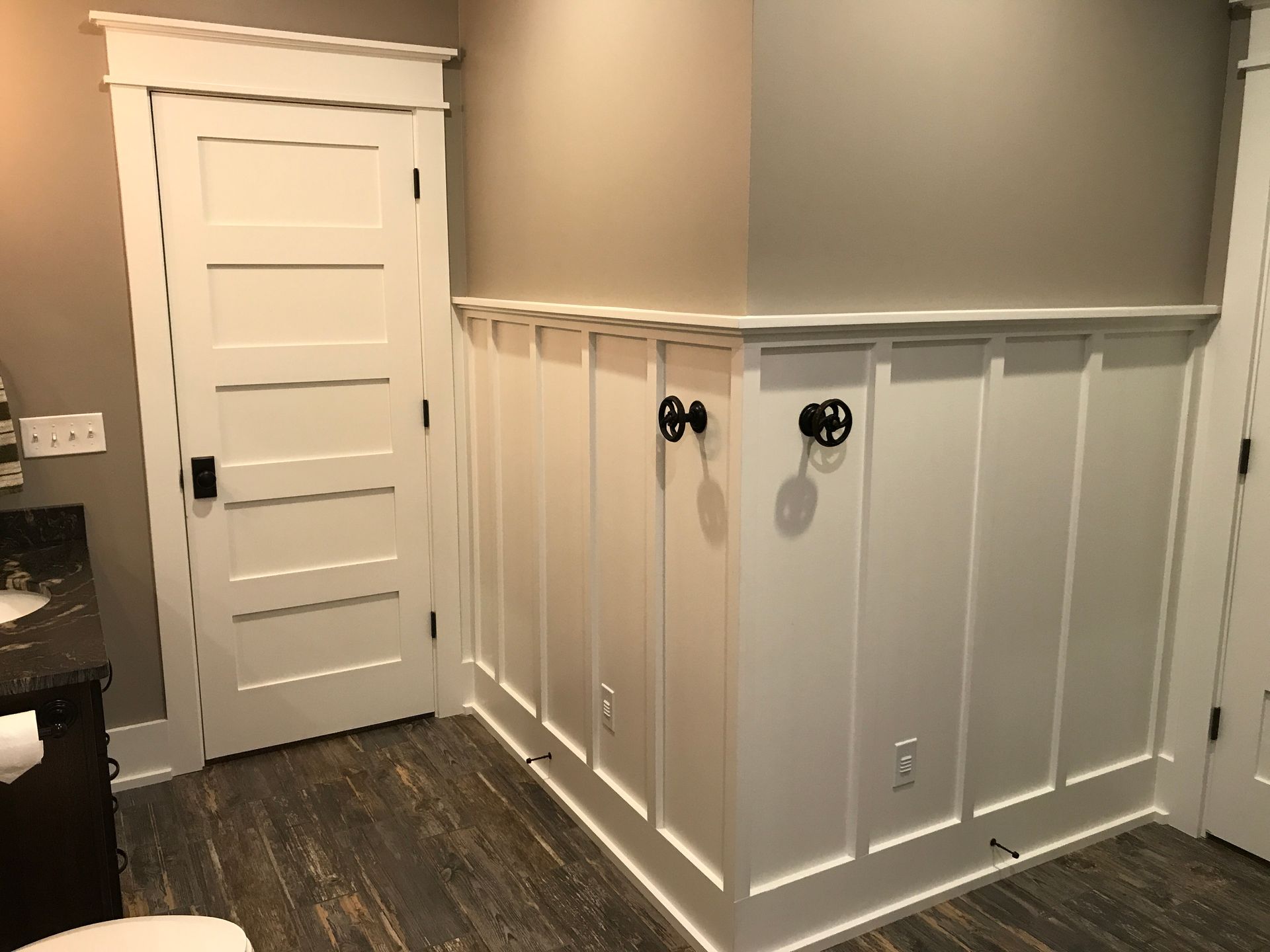 A bathroom with a toilet , sink , and door.
