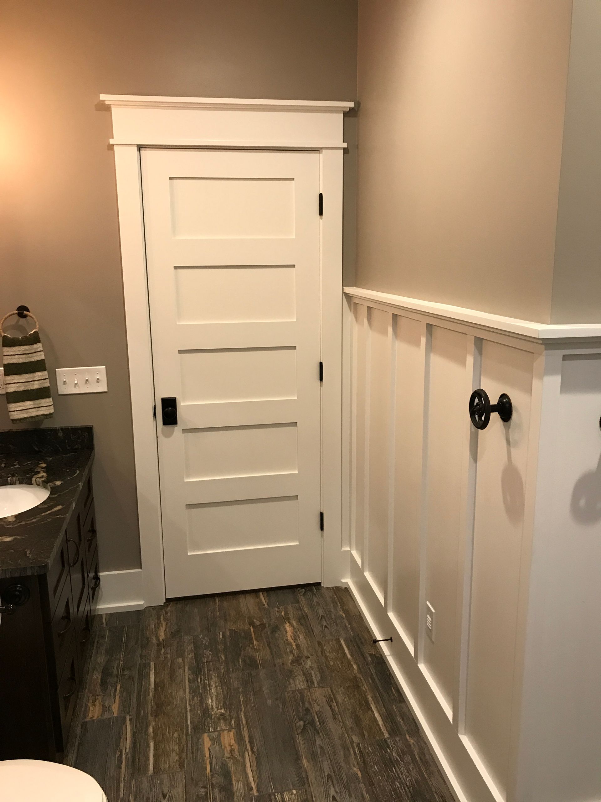 A bathroom with a toilet , sink , and door.