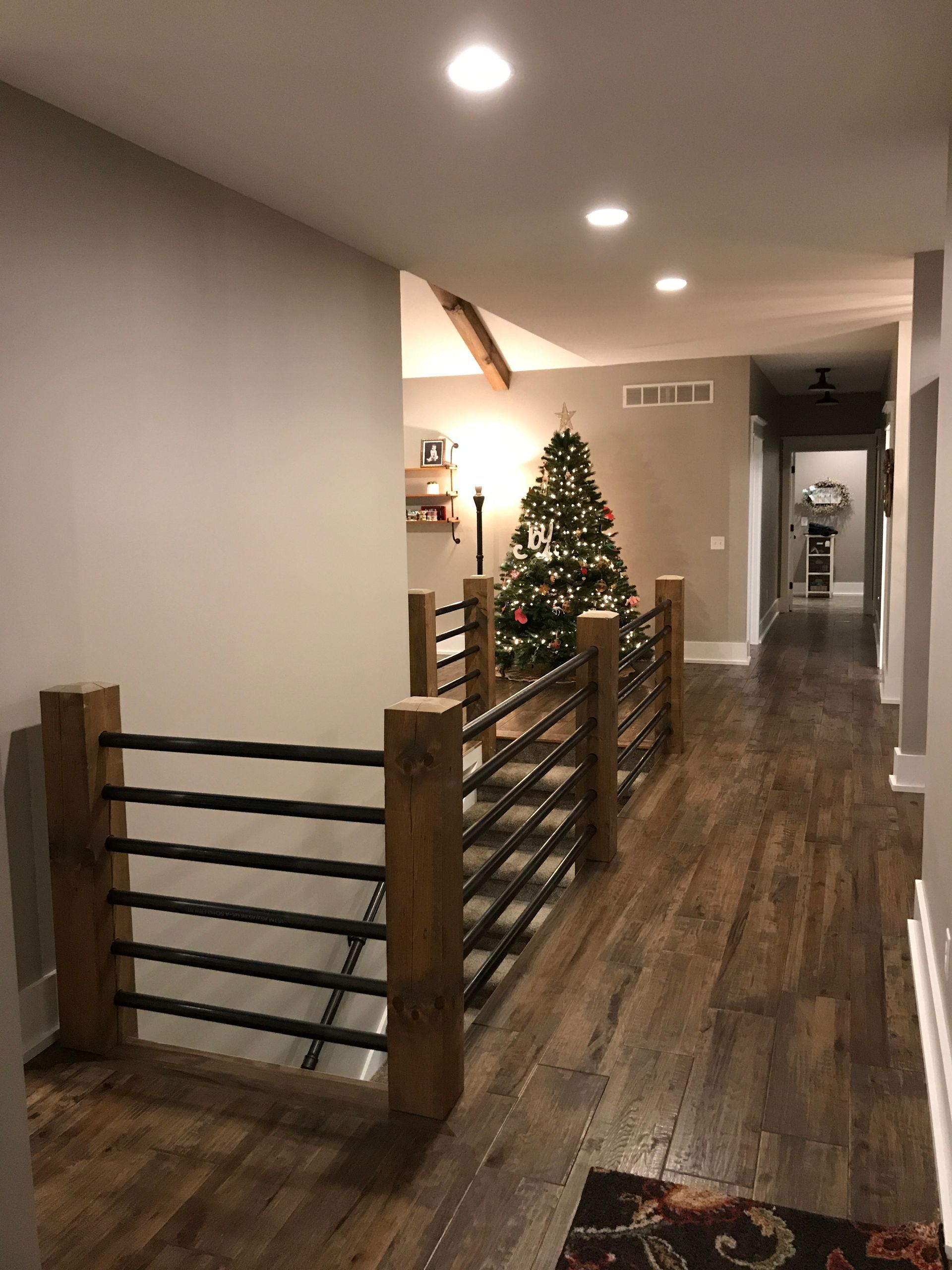 A hallway with a christmas tree in the middle of it.