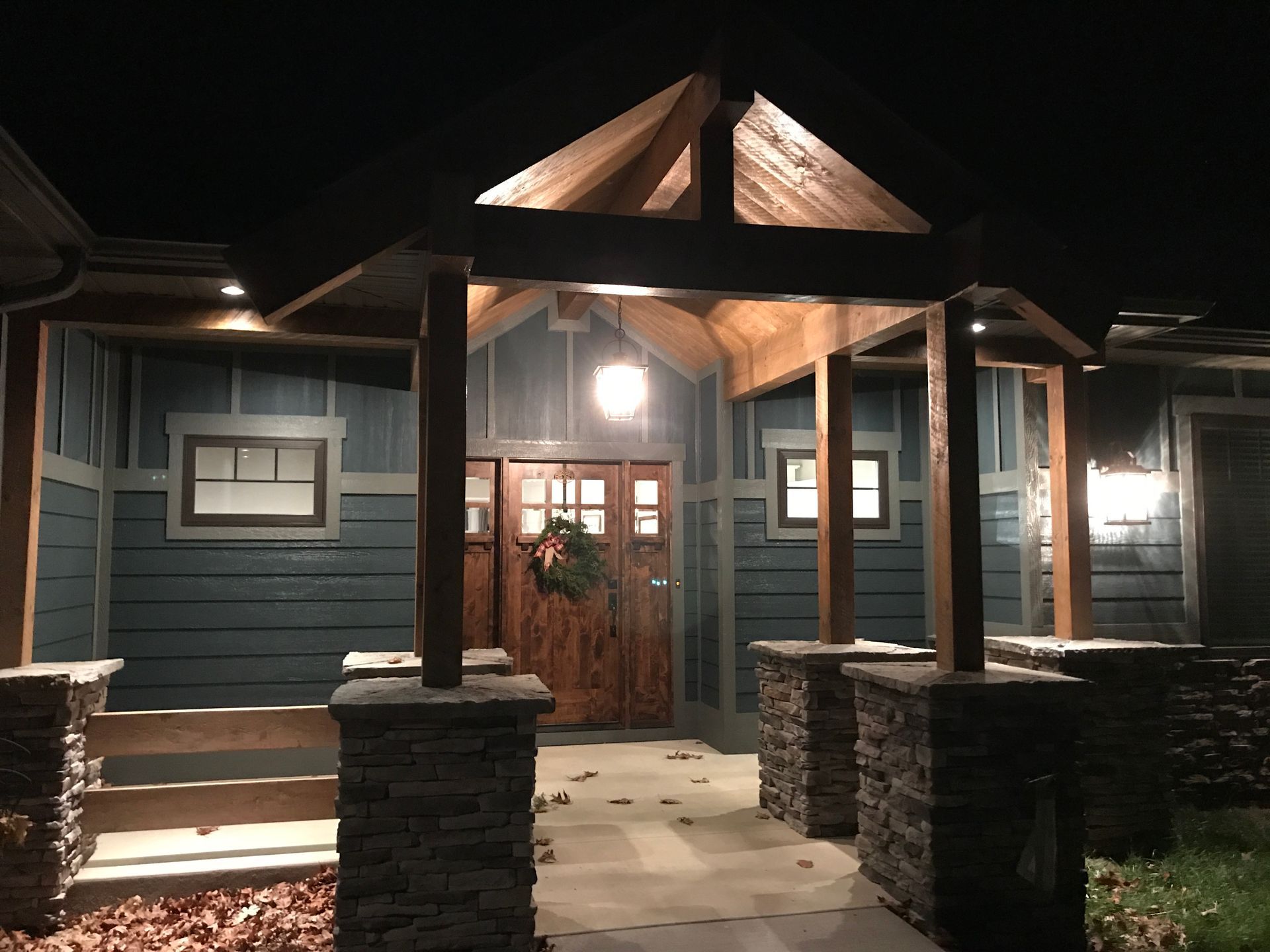 The front porch of a house is lit up at night