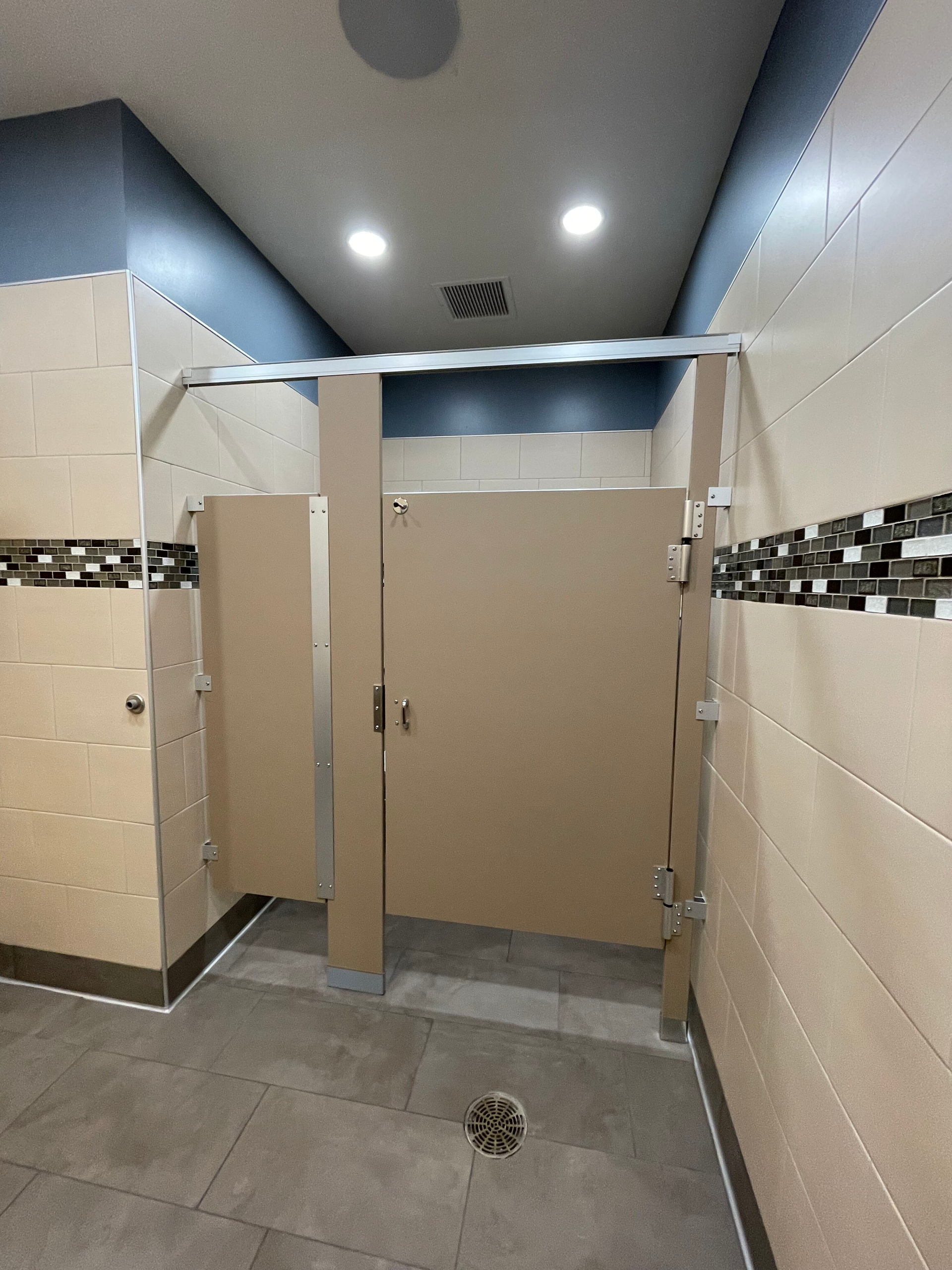 A bathroom with a shower stall and a drain