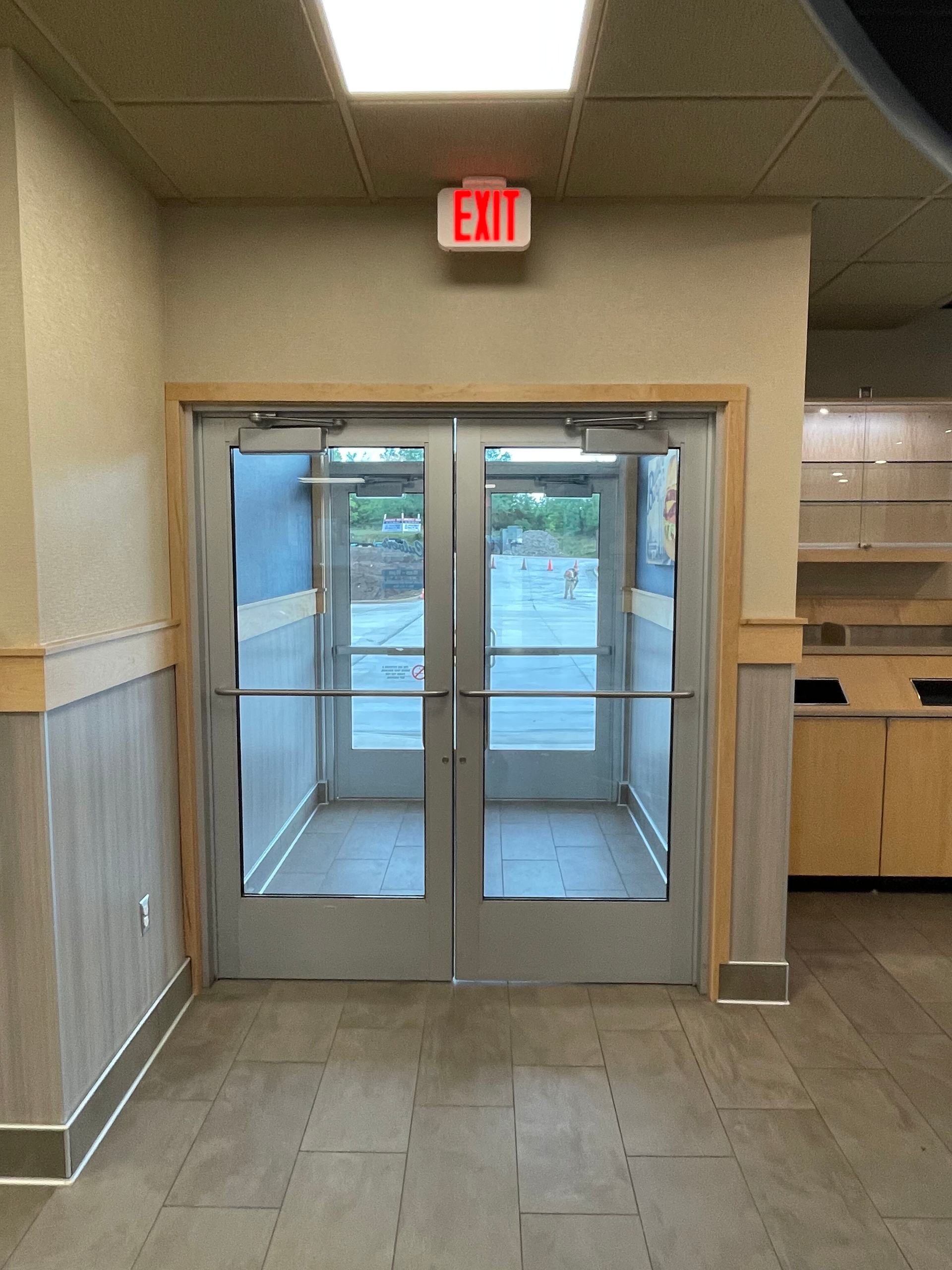 A red exit sign hangs above a doorway