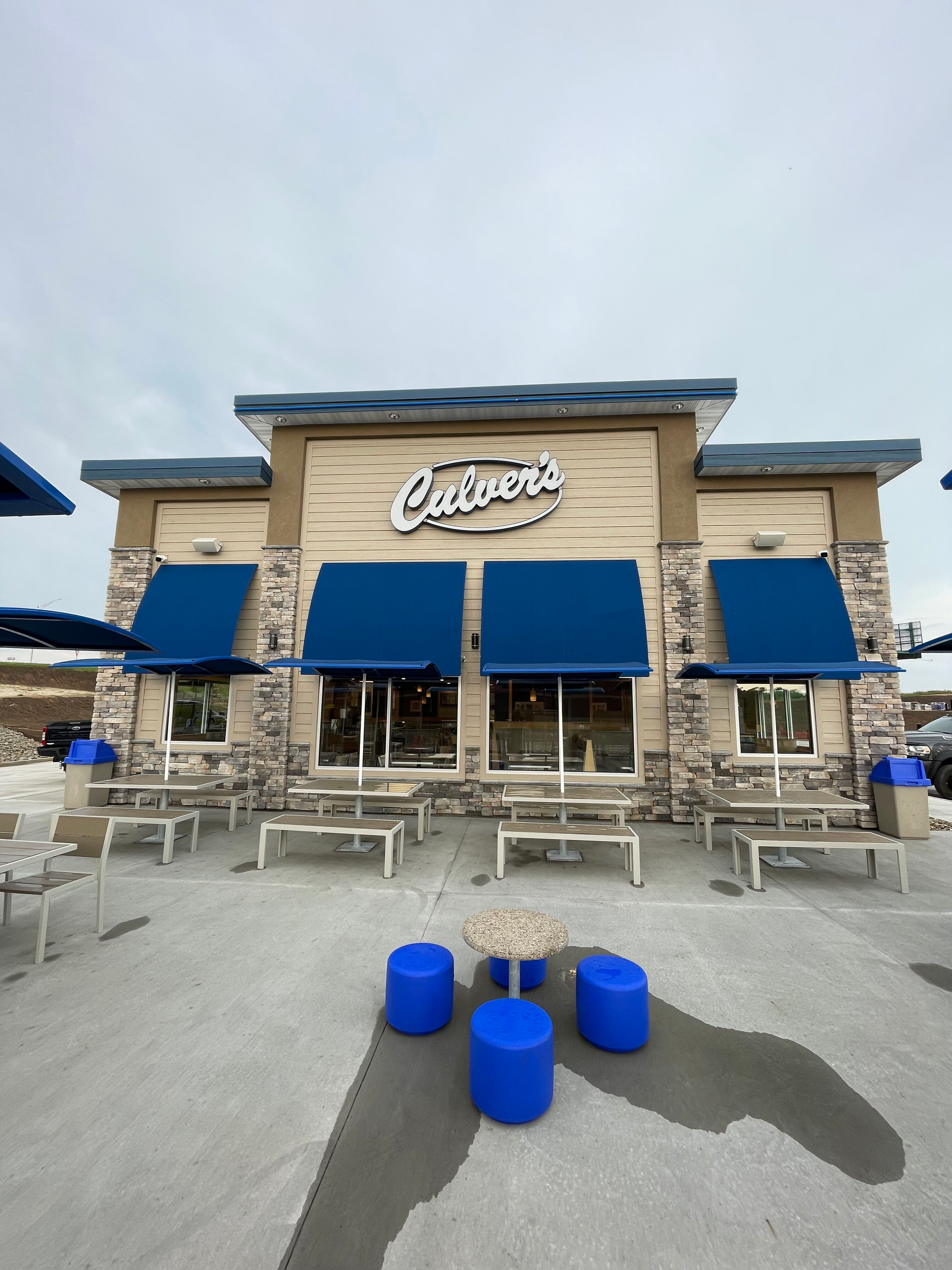 A calvera 's restaurant with blue awnings and blue ottomans