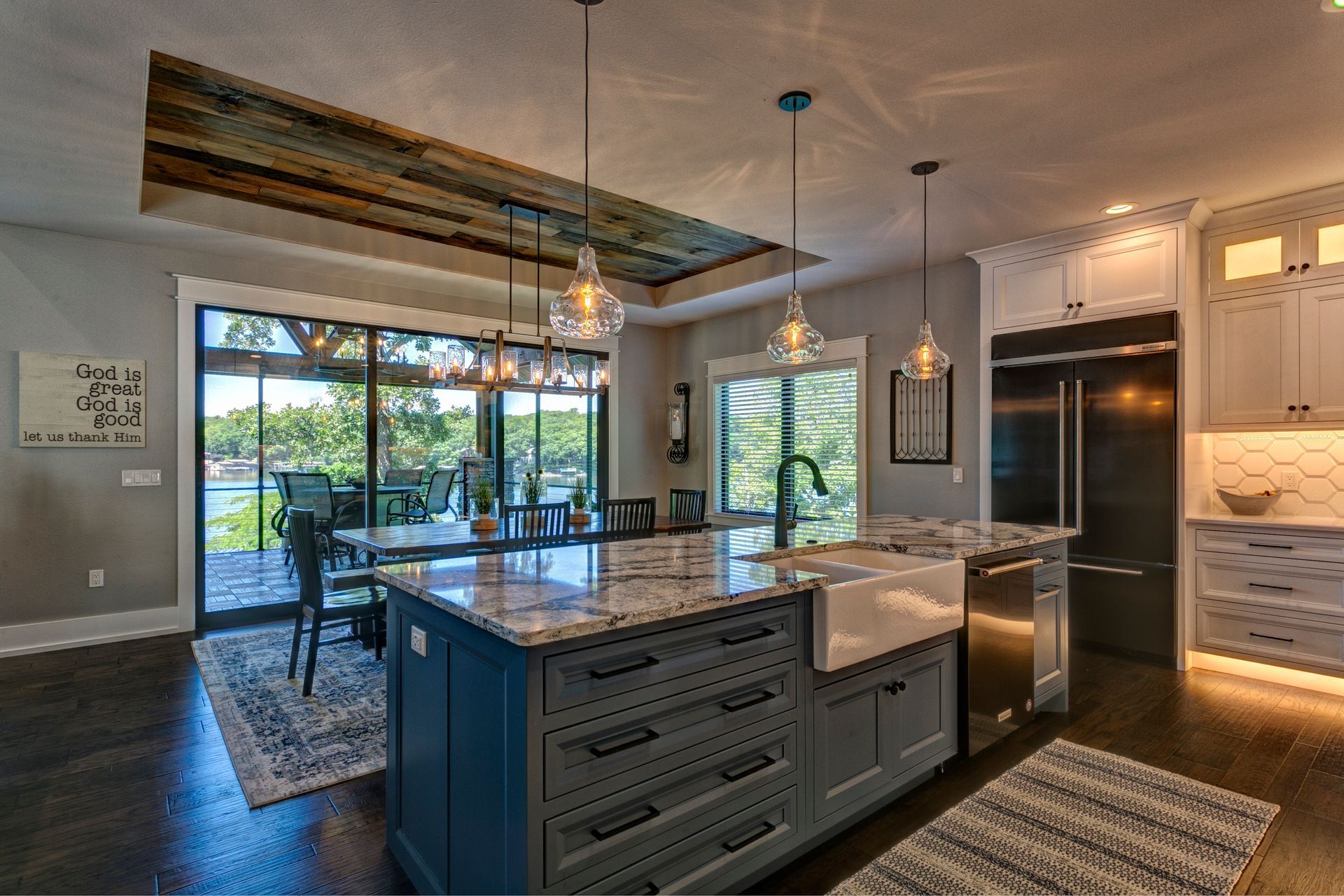 A kitchen with a large island , sink , refrigerator and stainless steel appliances.