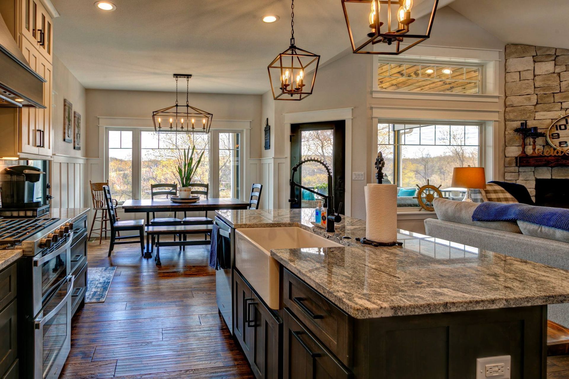 A kitchen with a sink , stove , dining table , and living room.