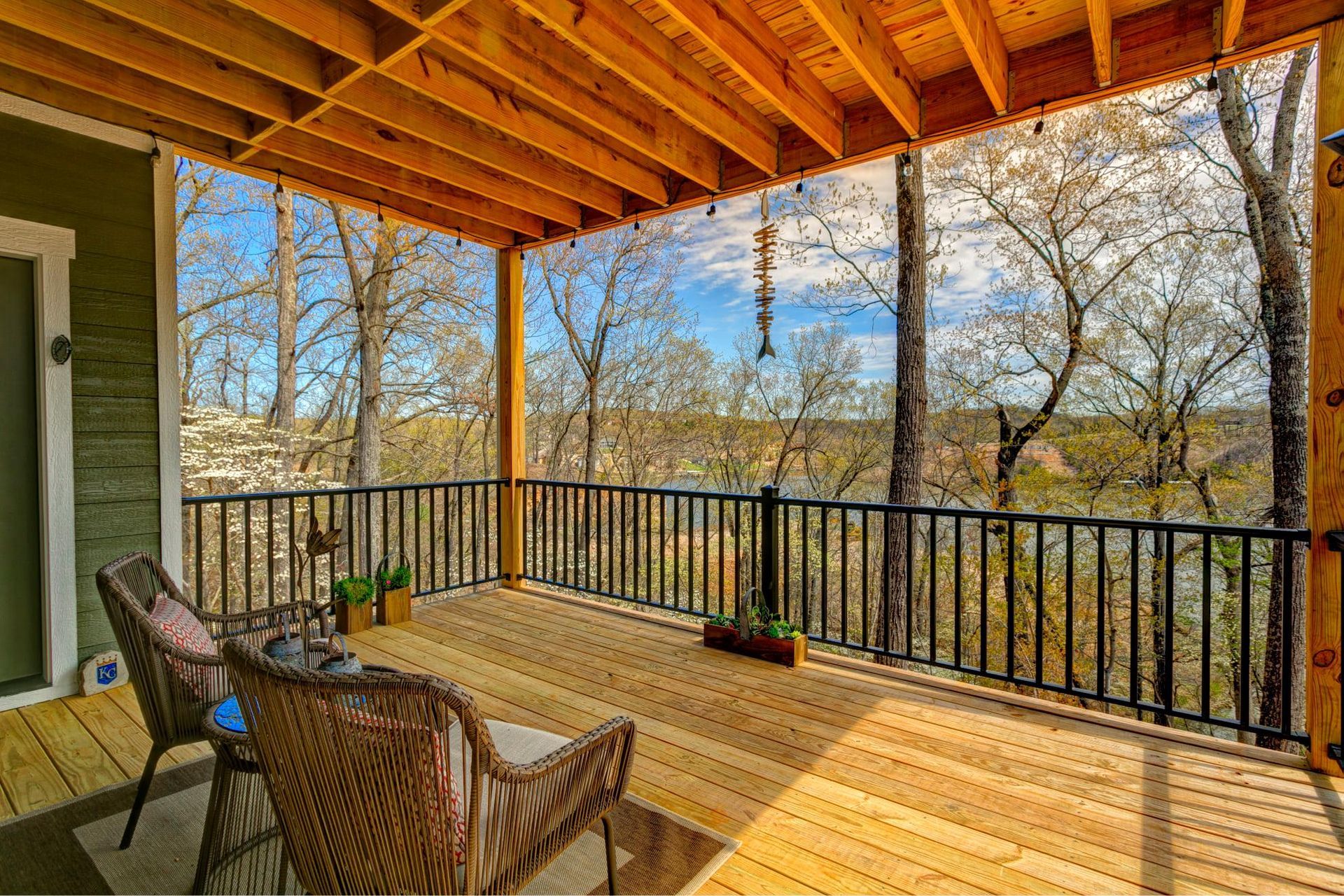 A screened in porch with a view of trees and a river.