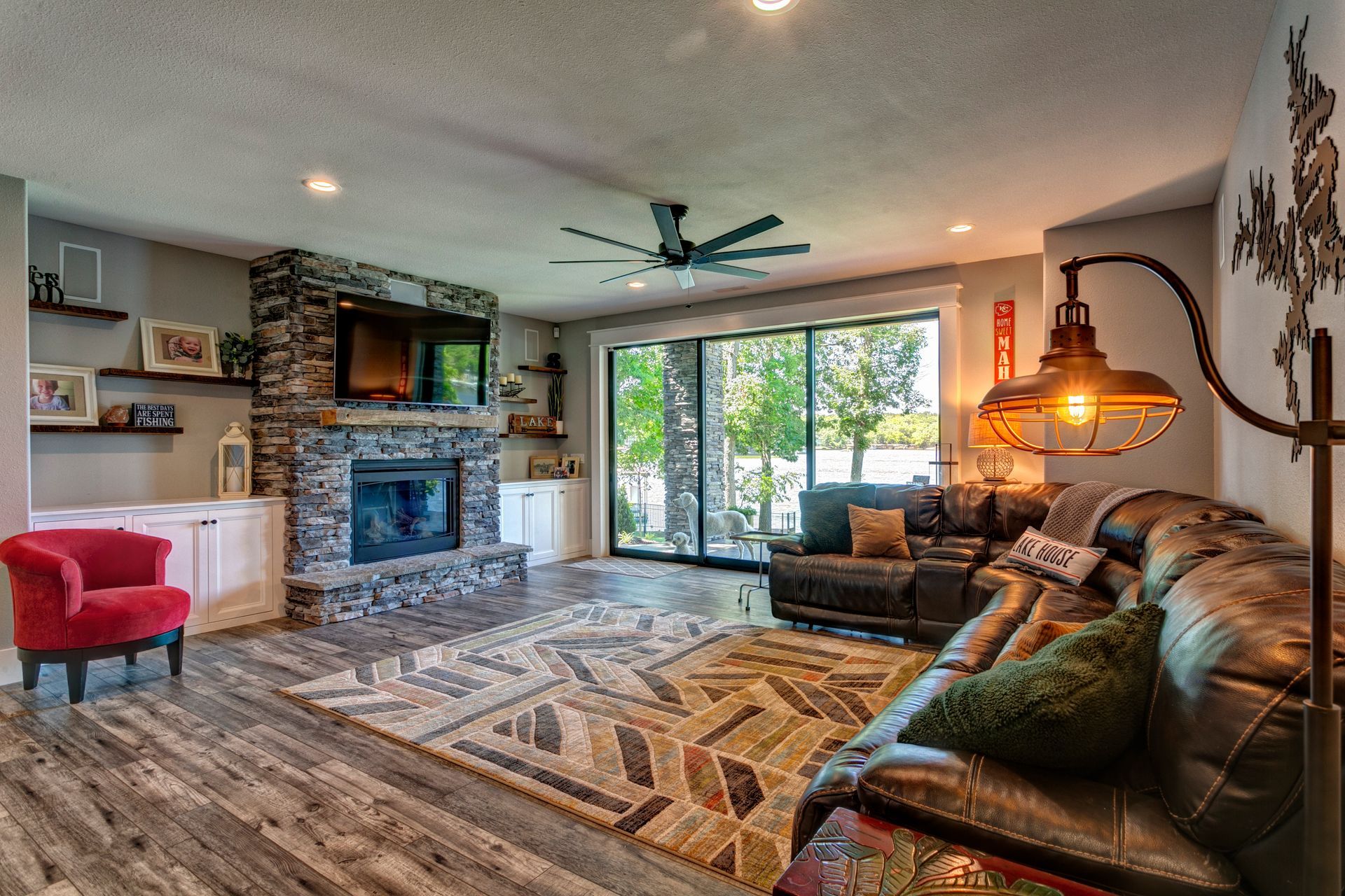A living room with a couch , chair , fireplace and sliding glass doors.
