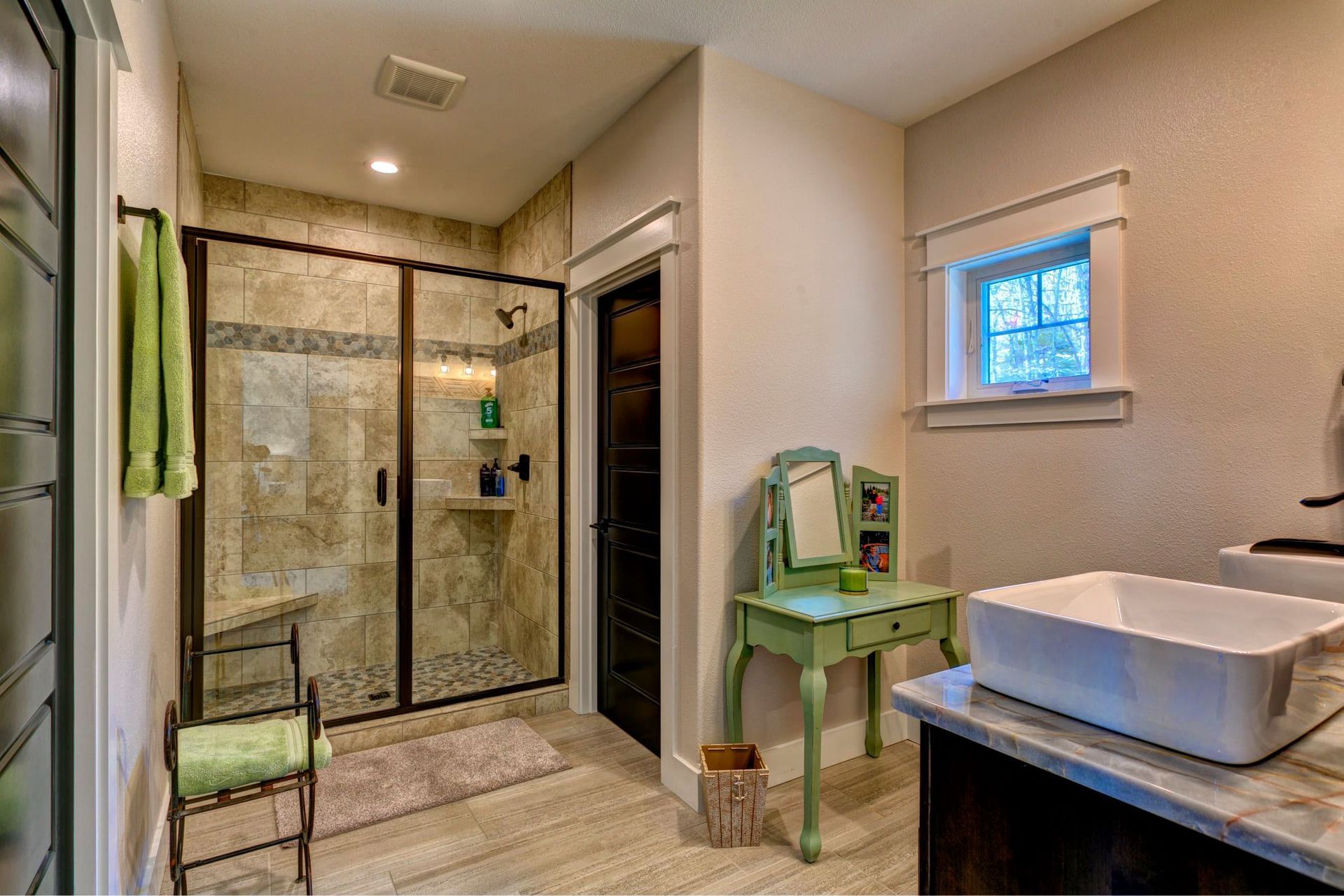 A bathroom with a sink , mirror and walk in shower.