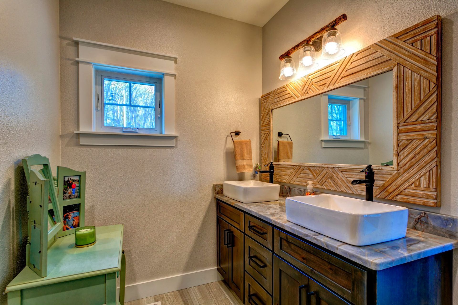 A bathroom with two sinks and a large mirror.