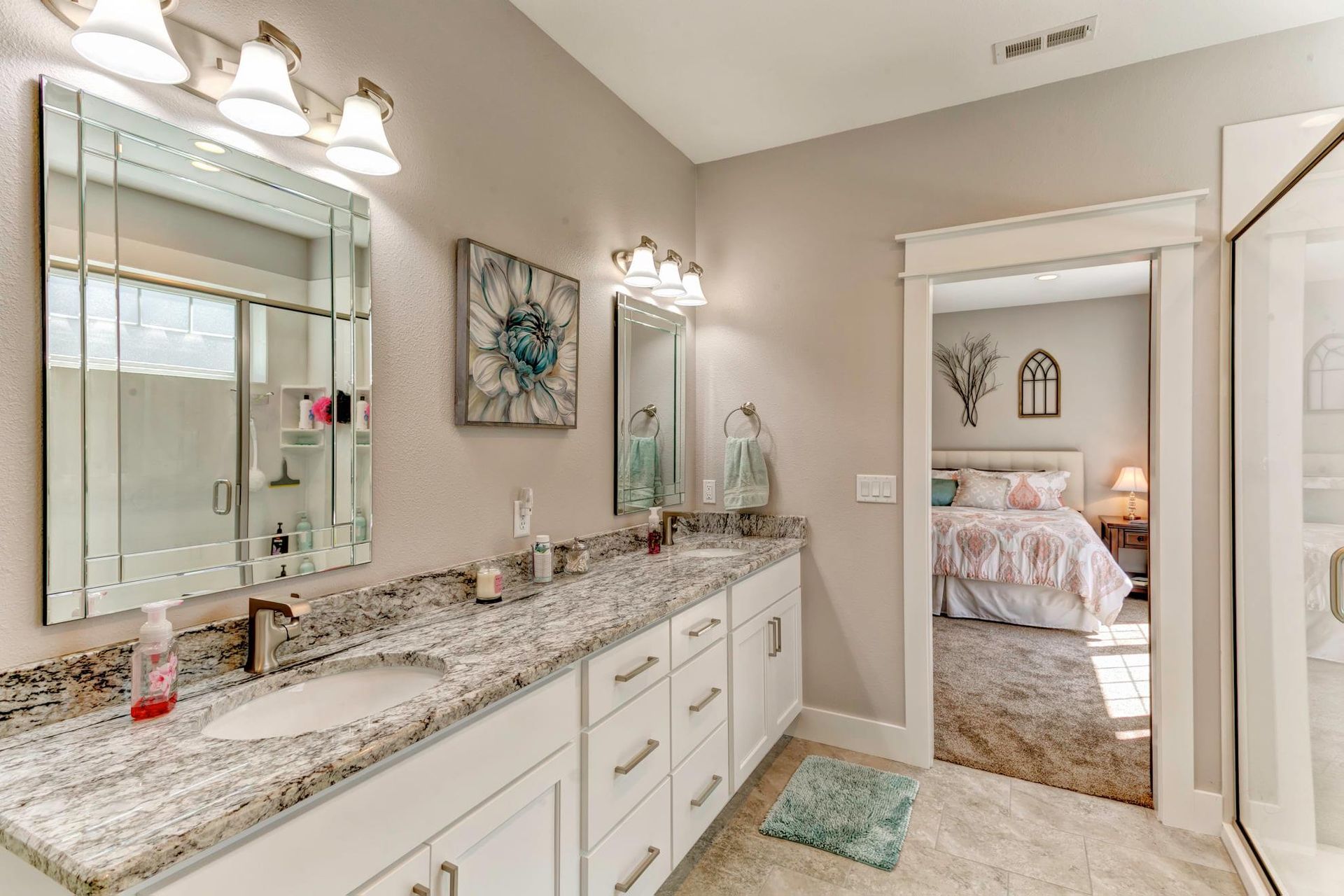 A bathroom with two sinks , a mirror and a walk in shower.