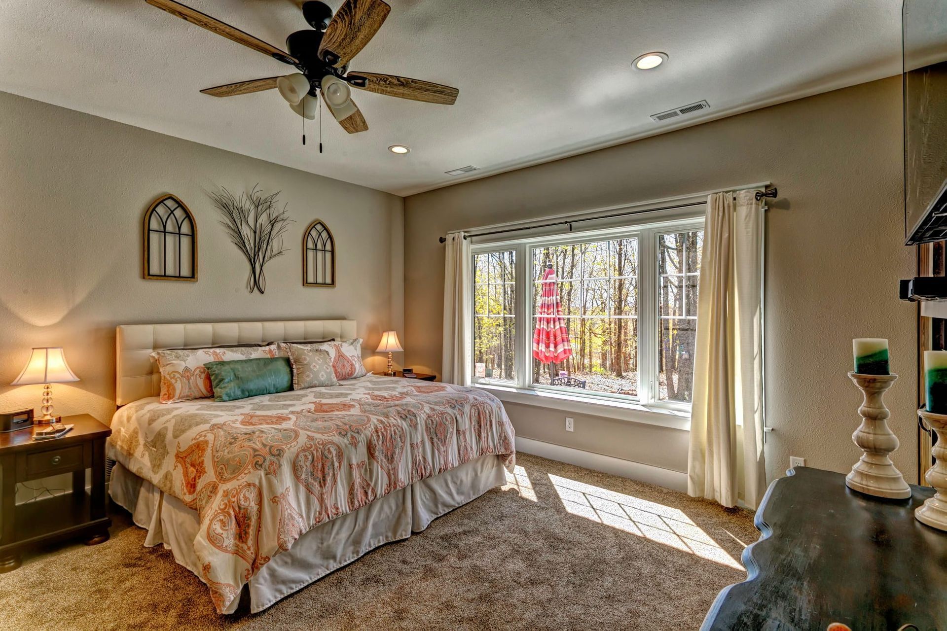 A bedroom with a large bed and a ceiling fan.