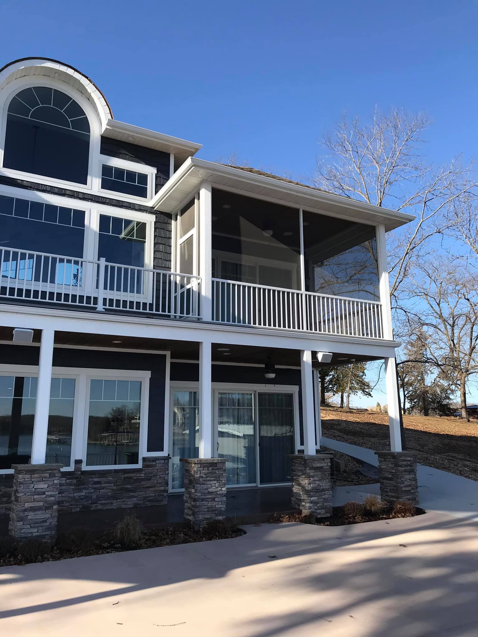 A large house with a large porch and a blue sky in the background