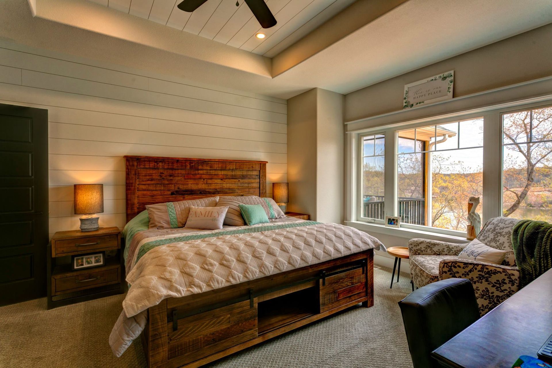 There is a large bed in the middle of the room with a ceiling fan.