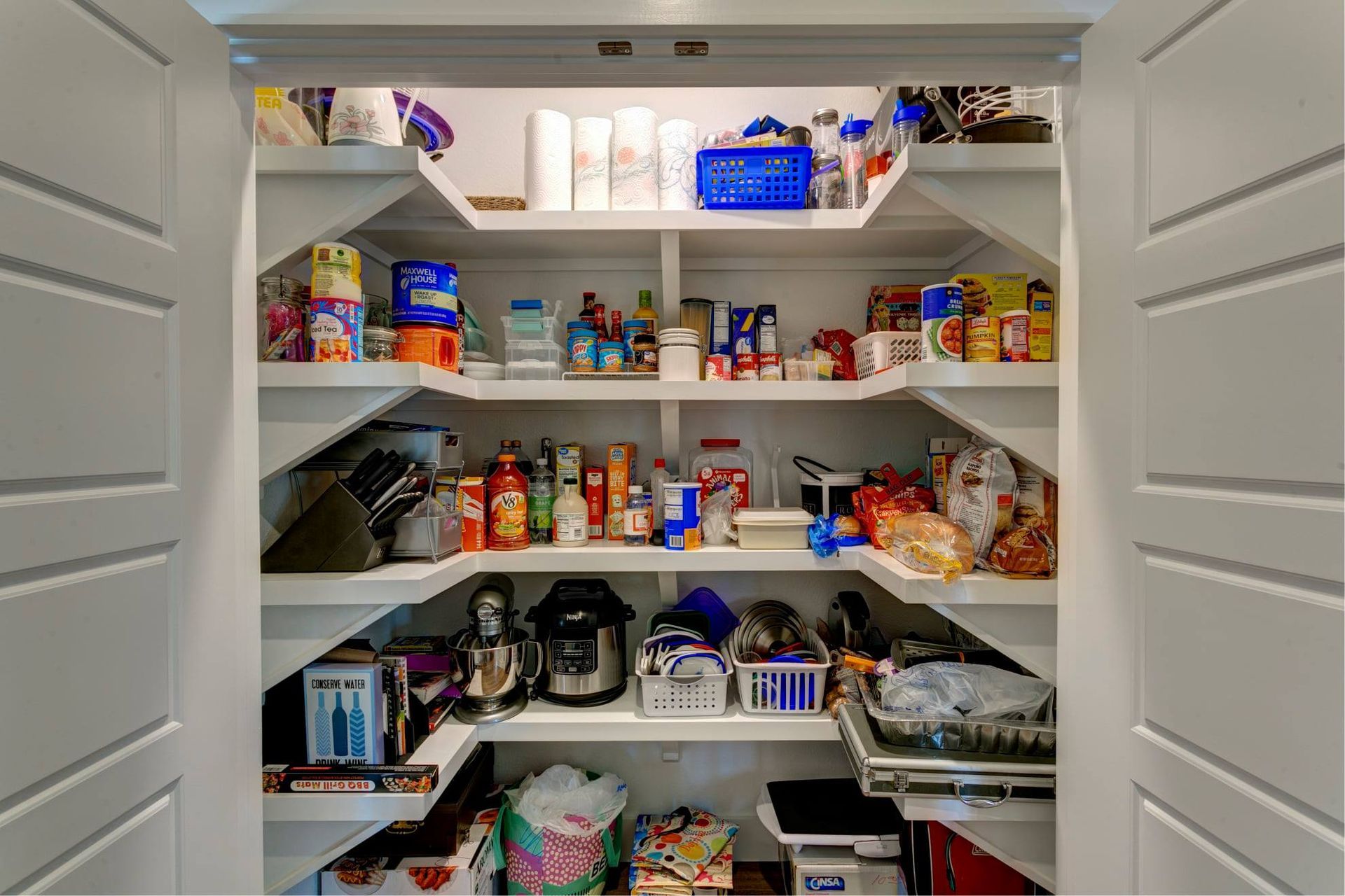 A pantry filled with lots of food and appliances.