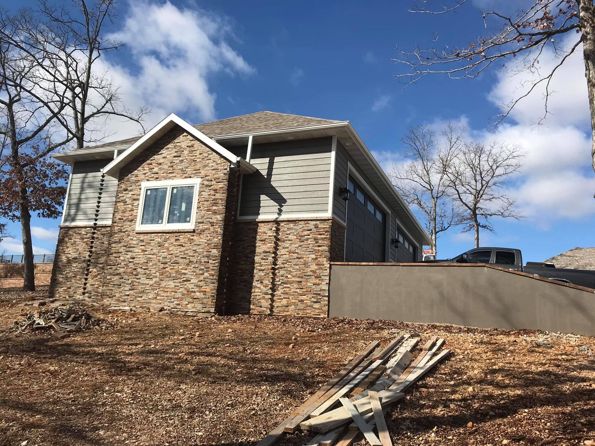 A brick house is sitting on top of a dirt hill.