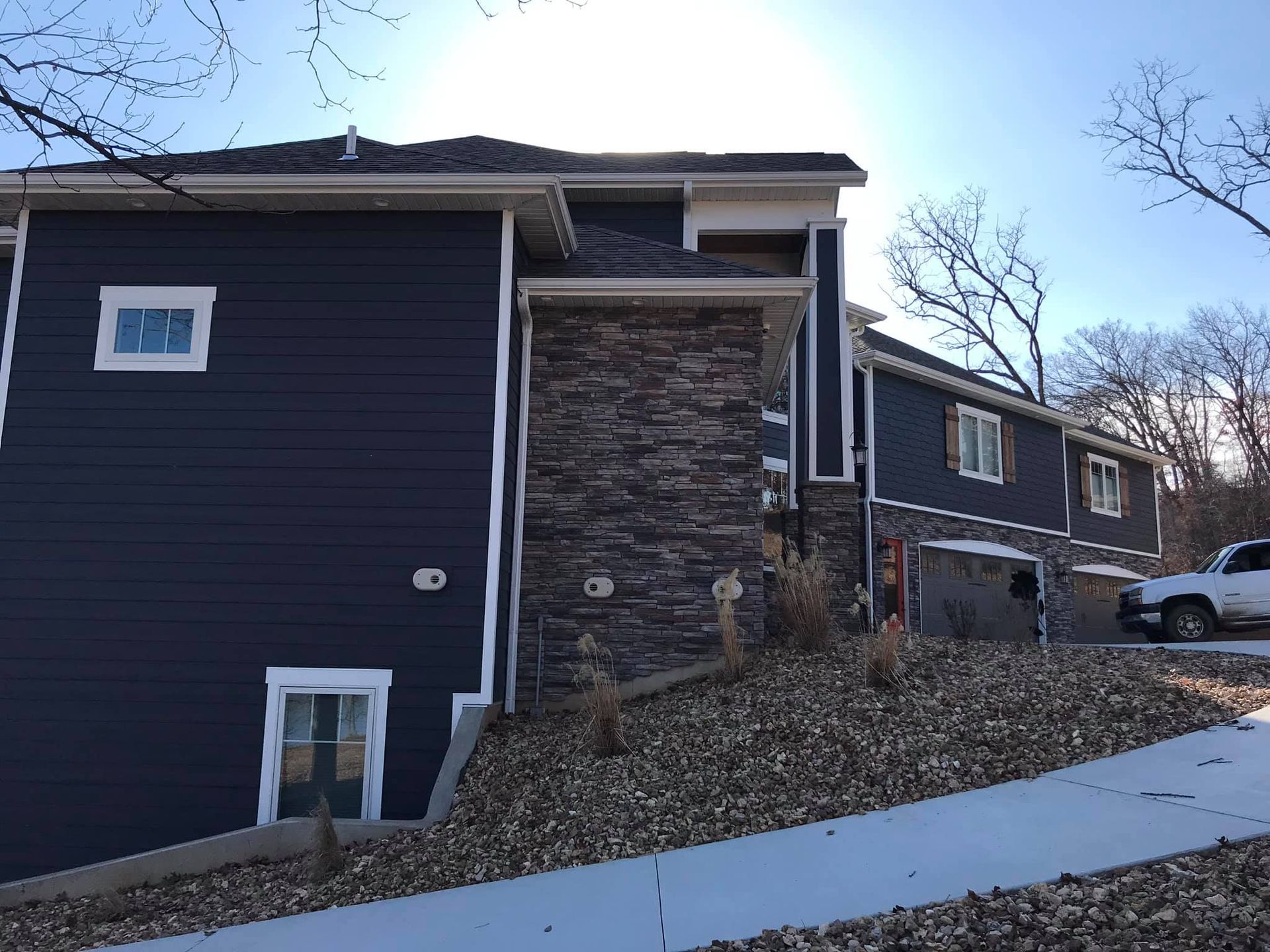A blue house with a white truck parked in front of it.