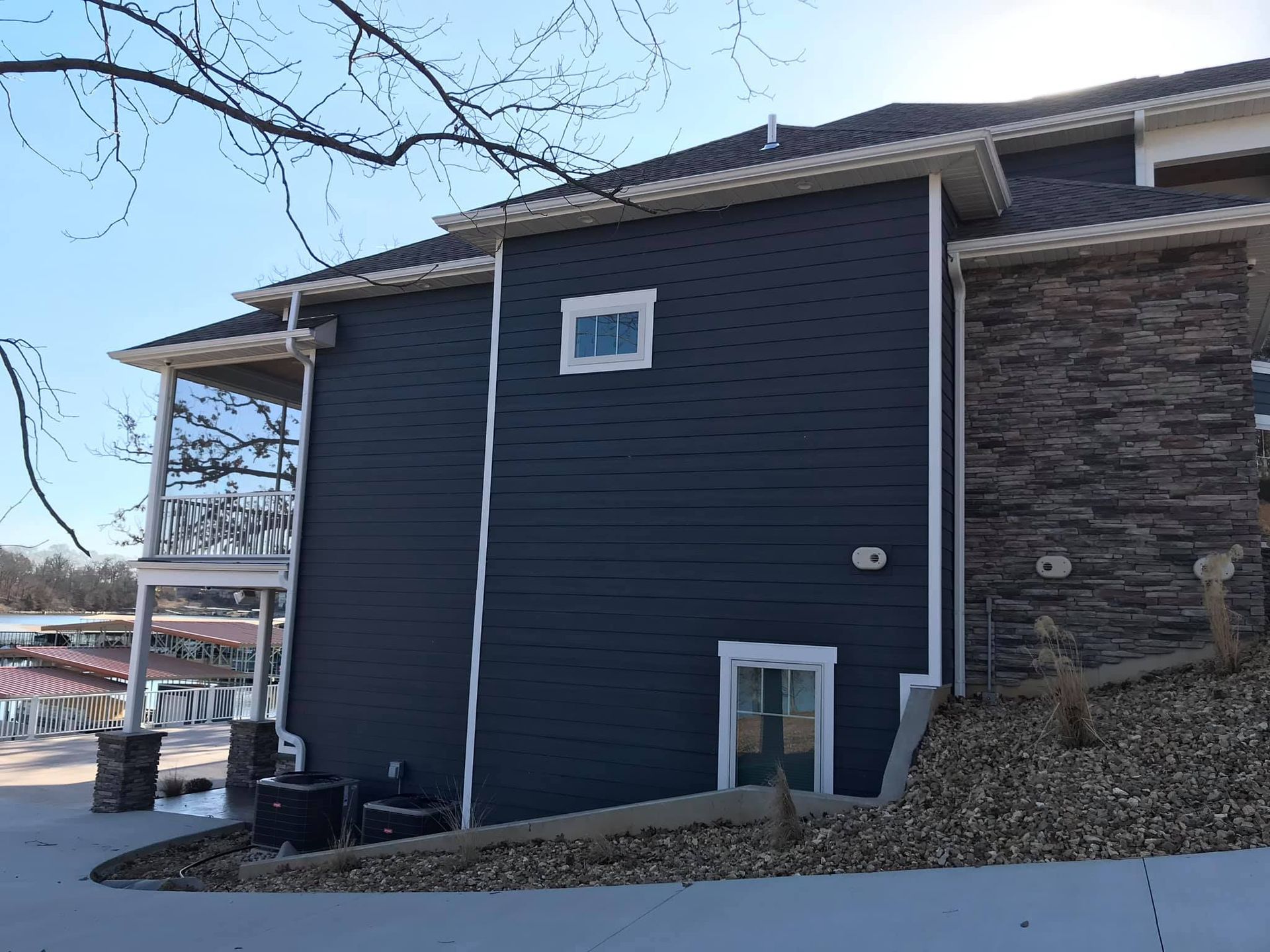 A large house with a blue siding and a white window