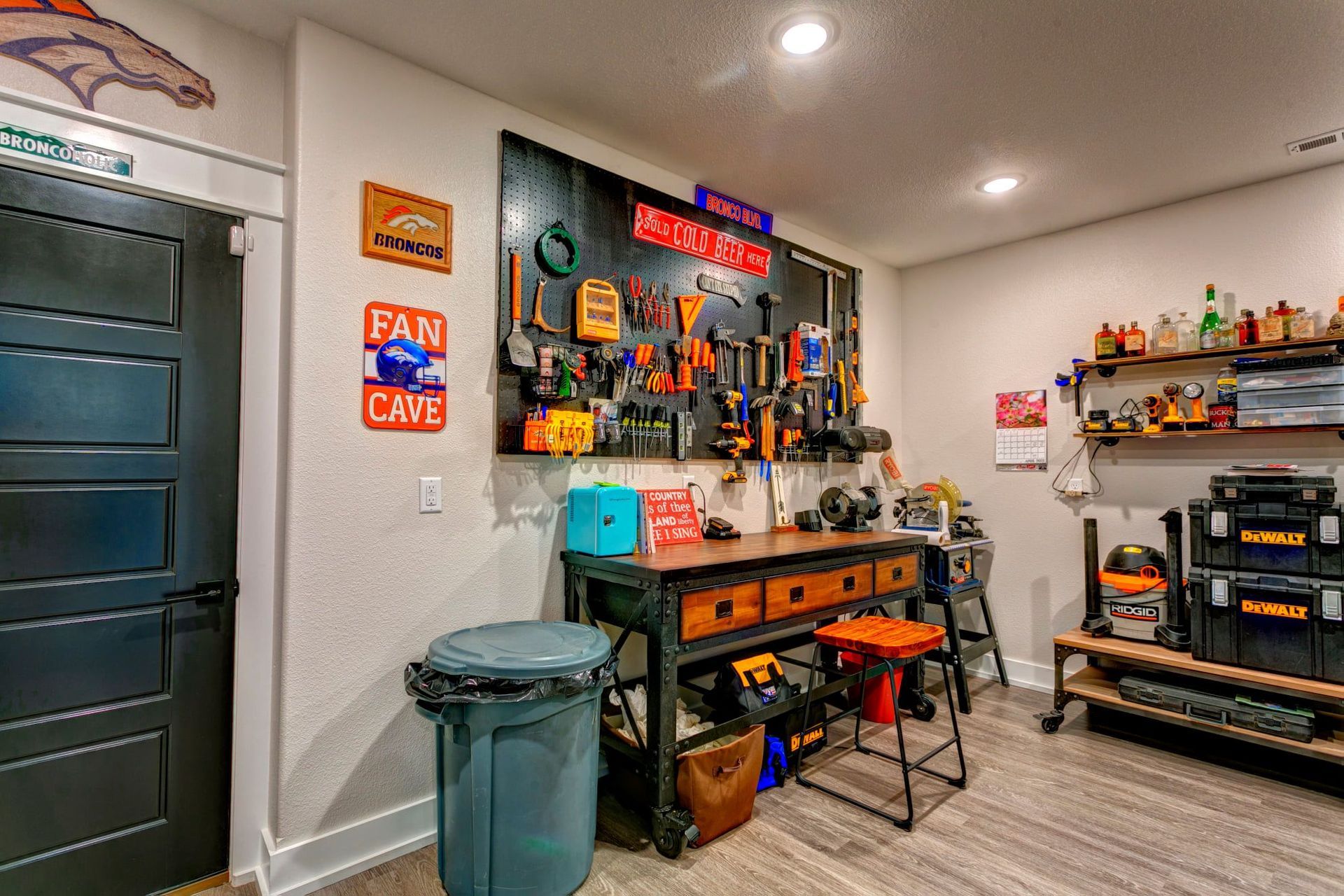 A garage with a workbench and a trash can.