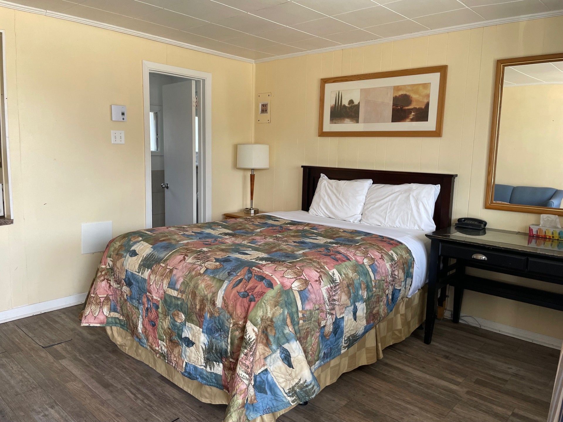 Une chambre d'hôtel avec un lit king size et un miroir.