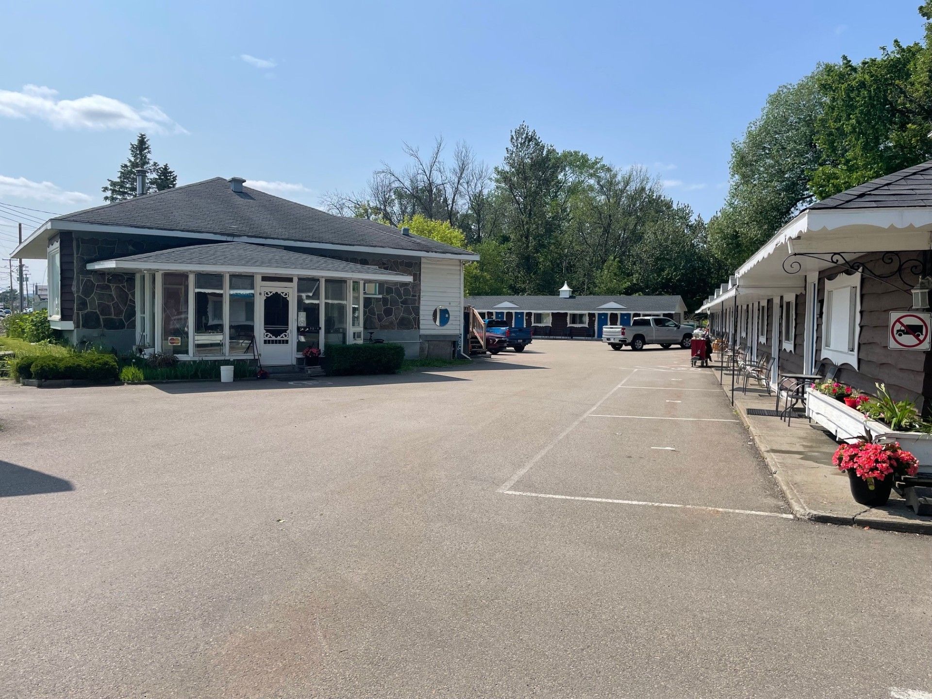 Un motel avec beaucoup de voitures garées devant.