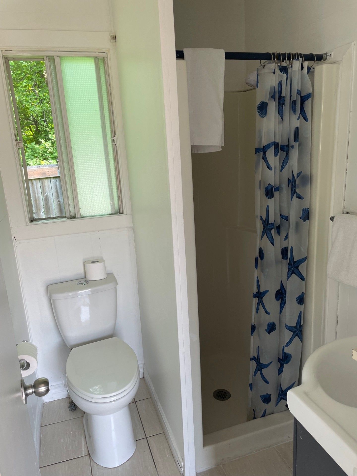 Une salle de bain avec toilettes, un lavabo et une douche