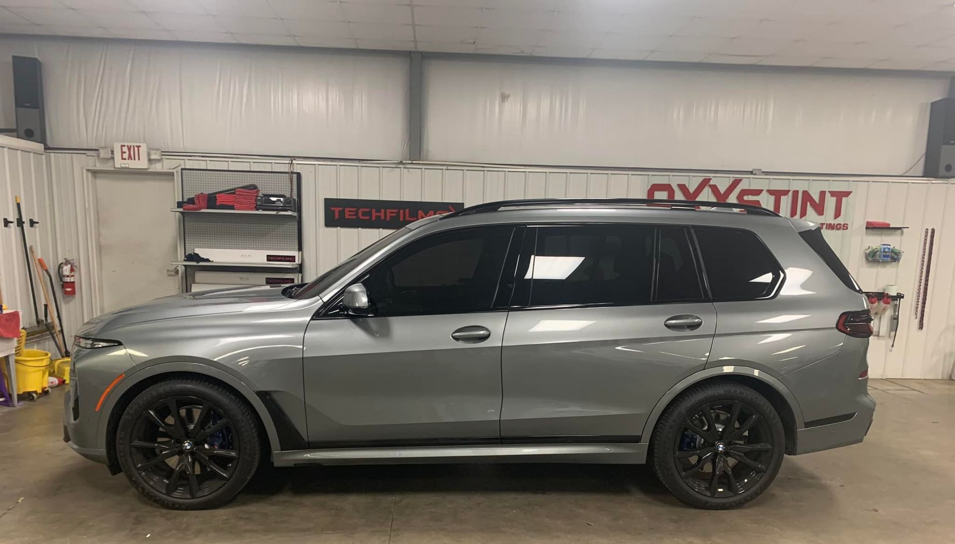 A gray bmw x7 is parked in a garage.