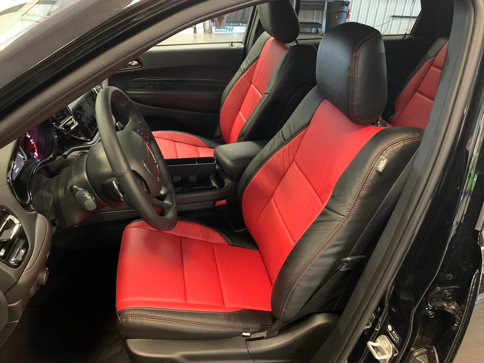 The interior of a black car with red and black seats