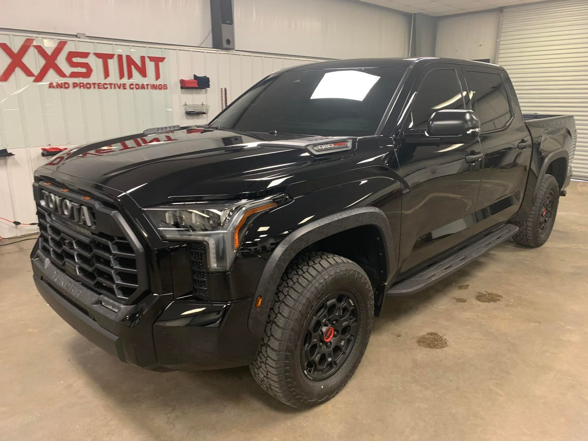 A black toyota tundra is parked in a garage.