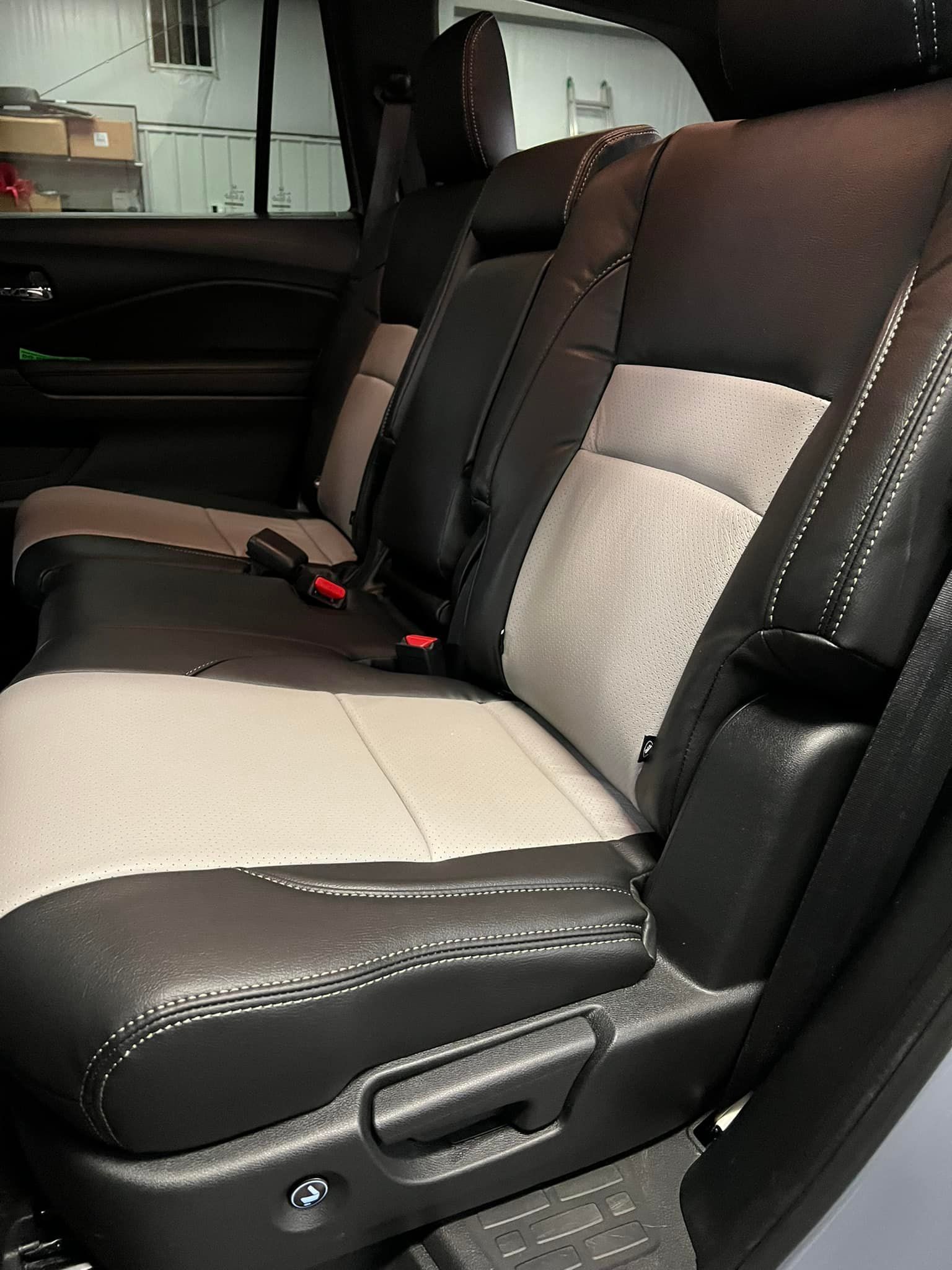 The back seat of a car with black and white seat covers