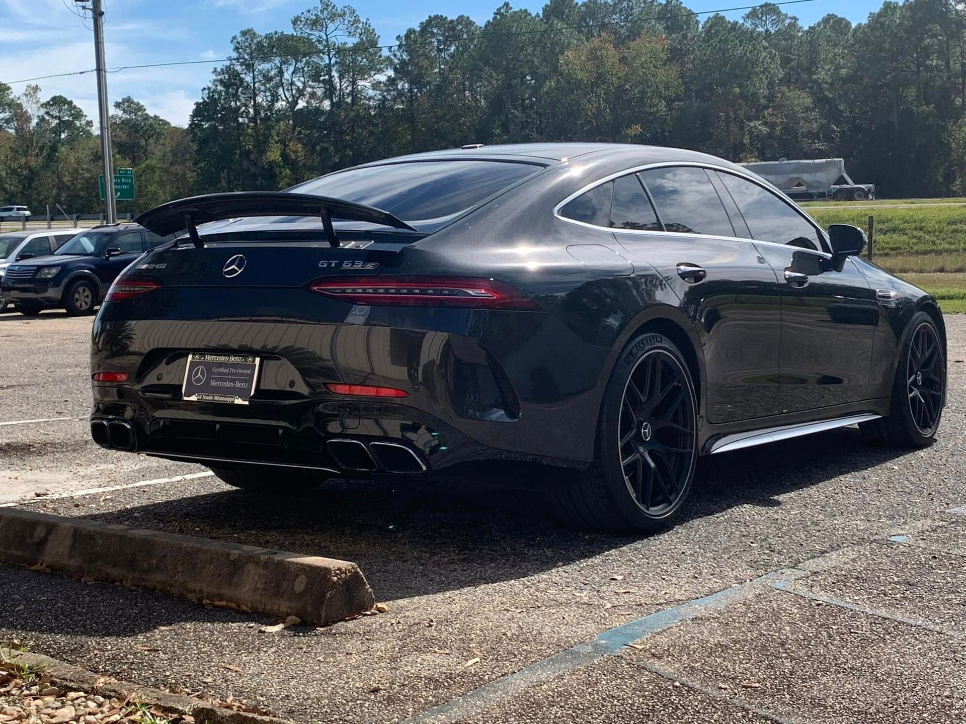 A black mercedes benz amg gt 63 s is parked in a parking lot.