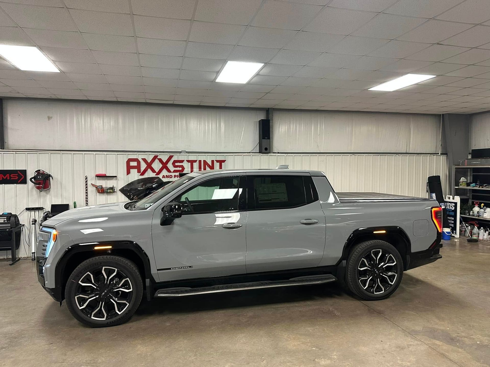 A gray pickup truck is parked in a garage.