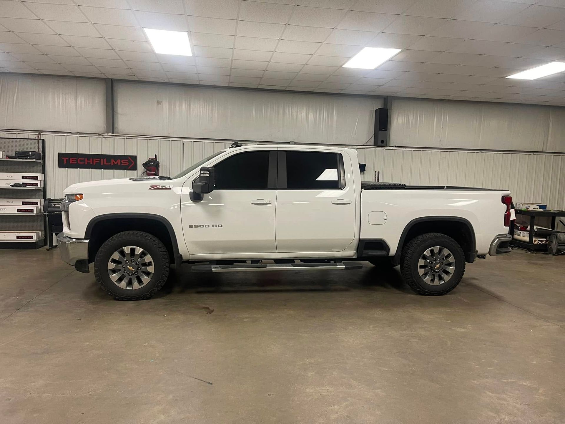 A white pickup truck is parked in a garage.