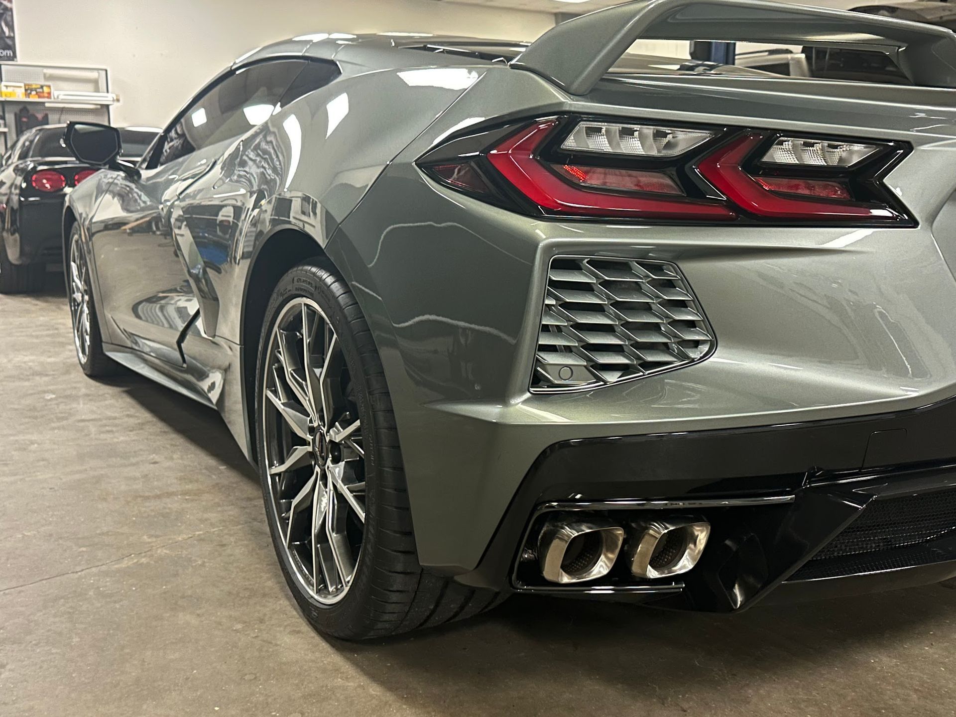 A gray sports car is parked in a garage.