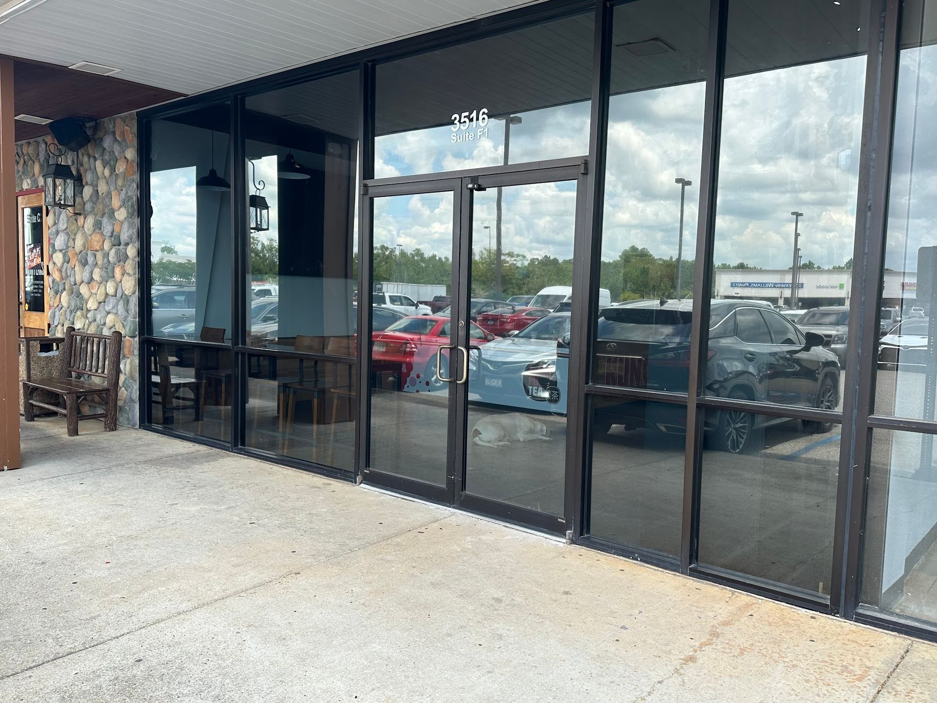 A building with a lot of windows and a lot of cars parked in front of it.