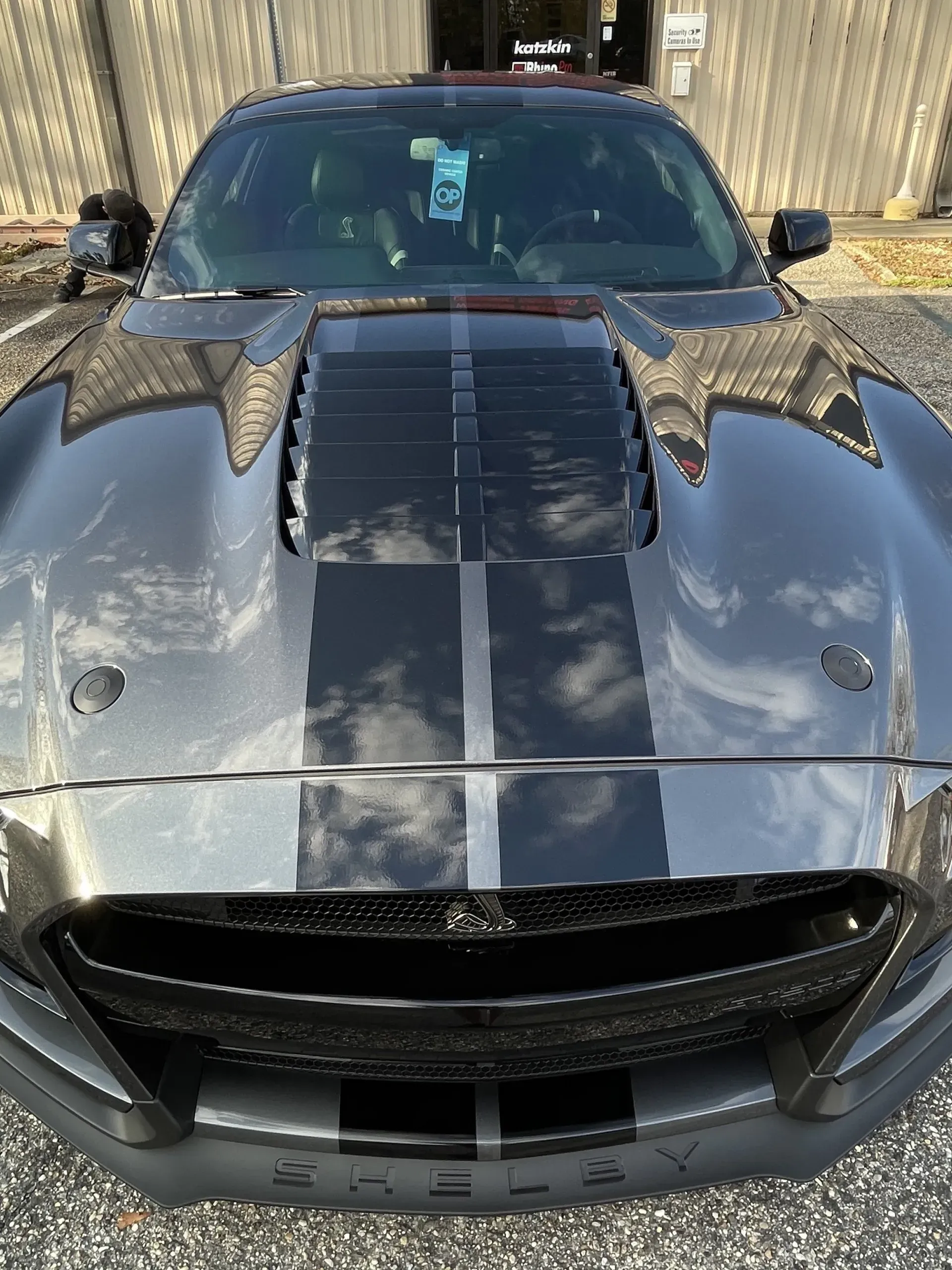 A black ford mustang is parked in front of a building.