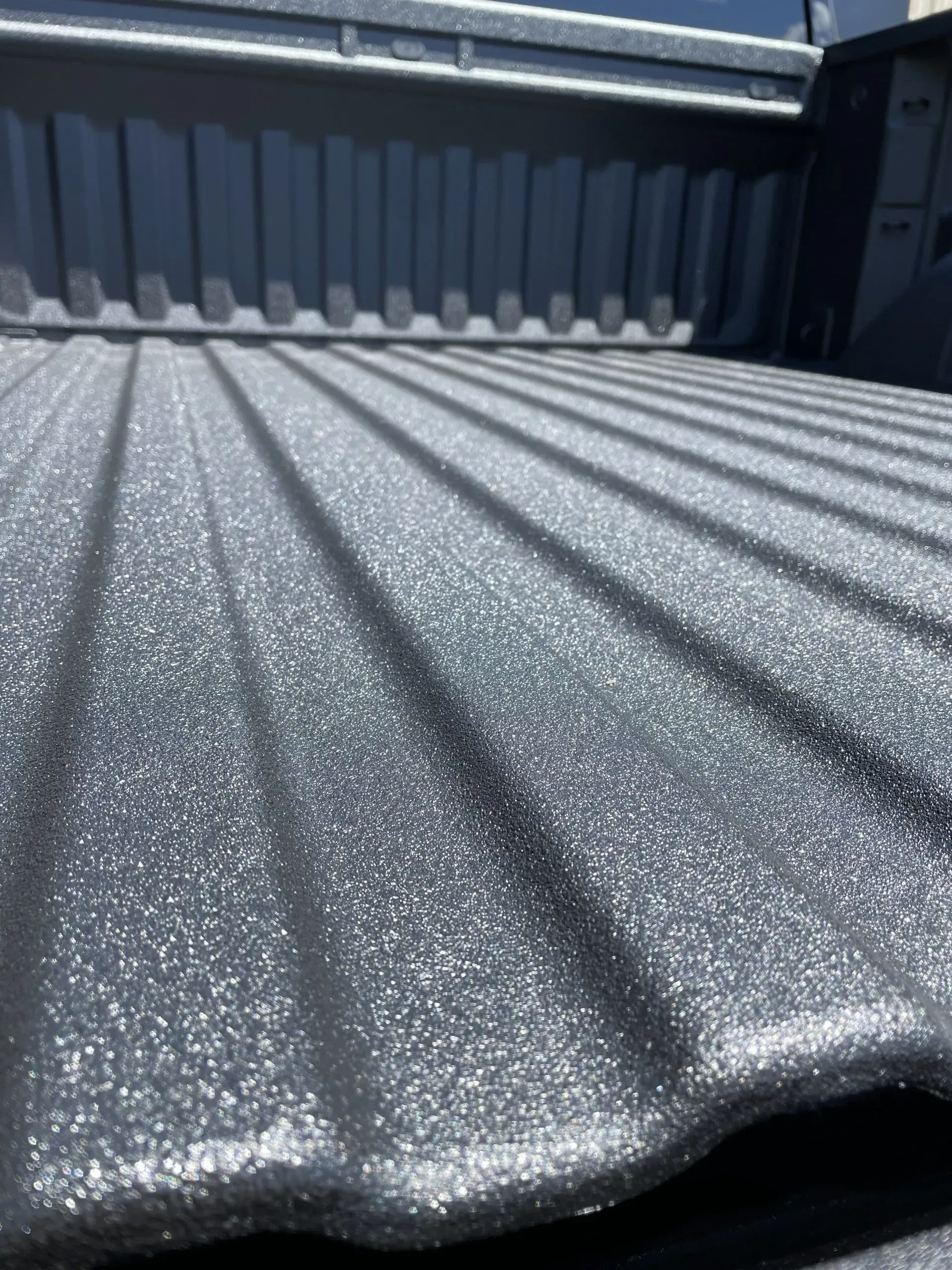 A close up of the bed of a truck painted black.