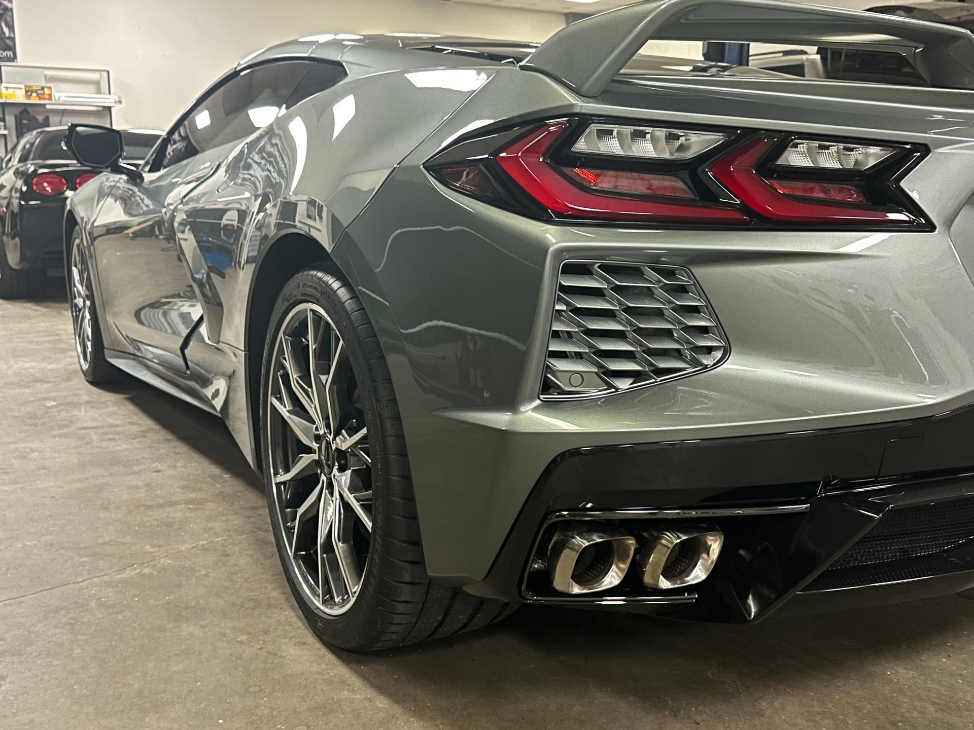 A white bmw x5 is parked in a garage with its doors open.