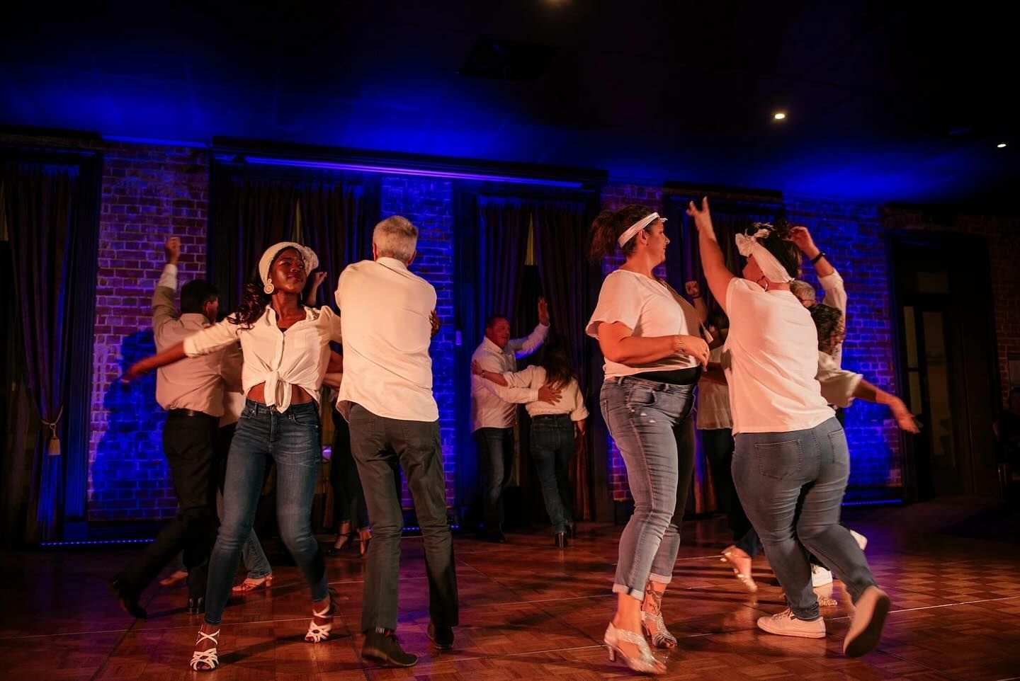 A Group Of People Are Dancing On A Stage In A Dark Room — Global Dance Collective In West End, QLD
