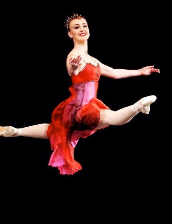 A Ballerina In A Red Dress Is Jumping In The Air — Global Dance Collective In West End, QLD