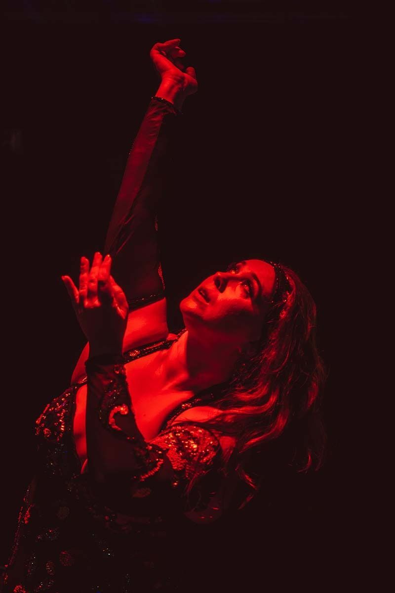 A Woman Is Singing Into A Microphone In A Dark Room — Global Dance Collective In West End, QLD