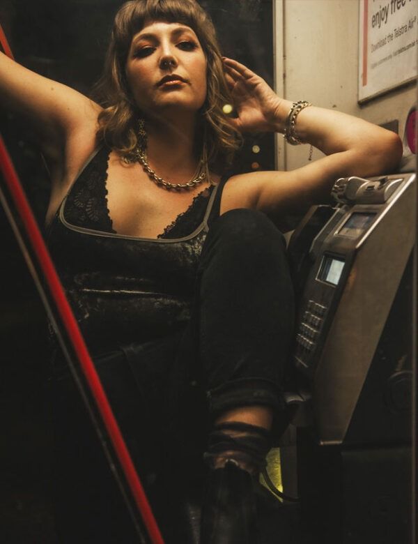 A Woman Is Sitting On A Staircase Next To A Pay Phone — Global Dance Collective In West End, QLD