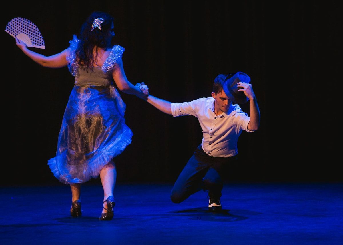 A Man And A Woman Are Dancing On A Stage In A Dark Room — Global Dance Collective In West End, QLD